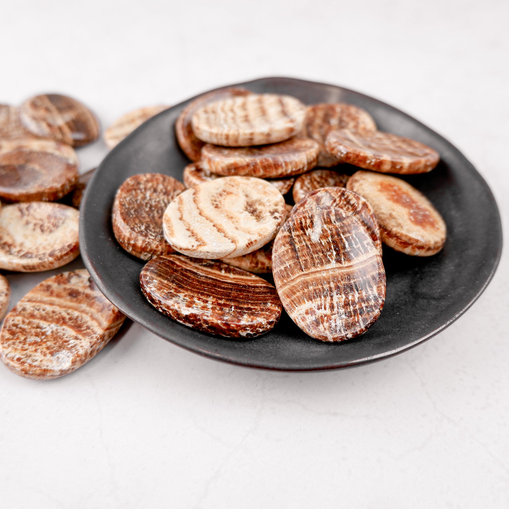 Smooth aragonite worry stone from Noctis Studio, features a polished, oval-shaped gemstone with natural white and beige tones.