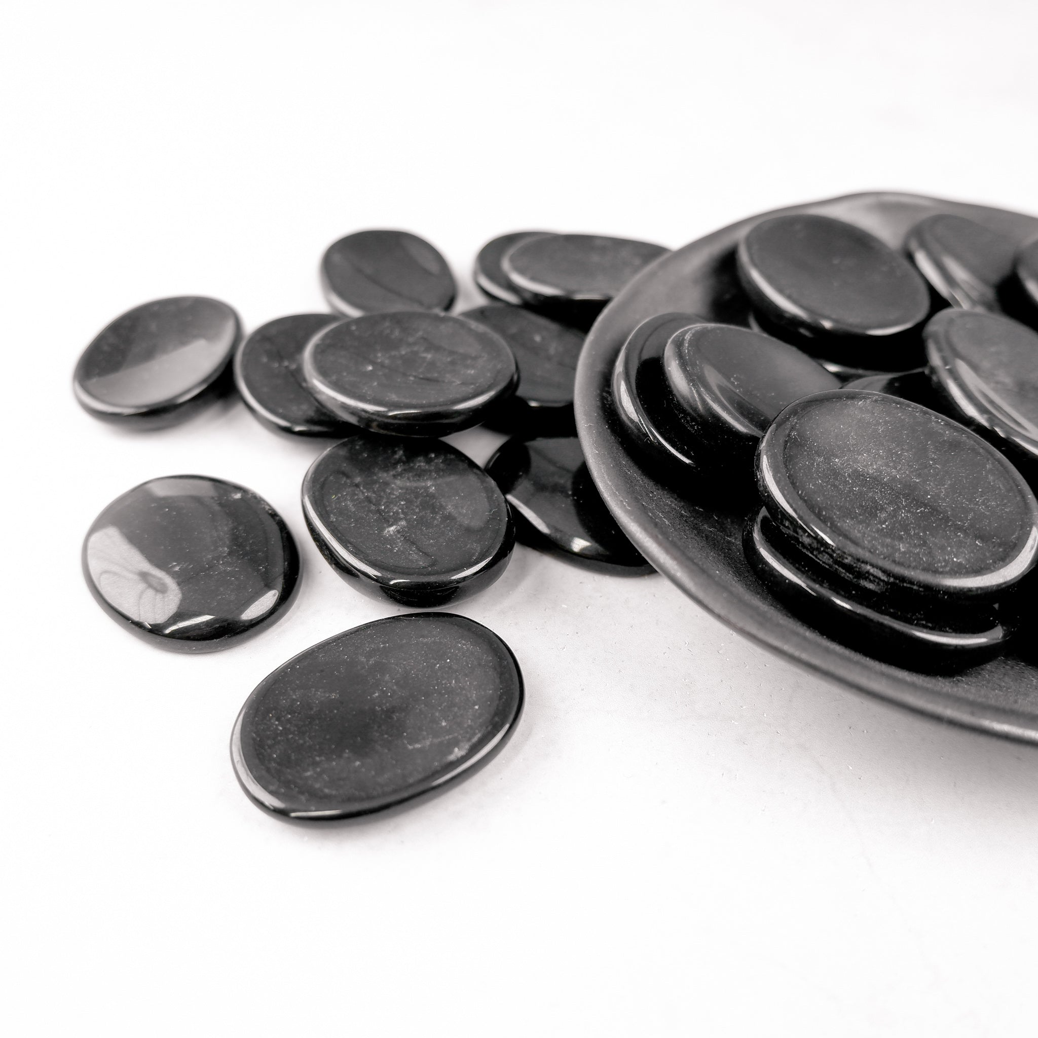 Black Jasper worry stone from Noctis Studio, smooth polished gemstone for stress relief and meditation, shown in close-up.