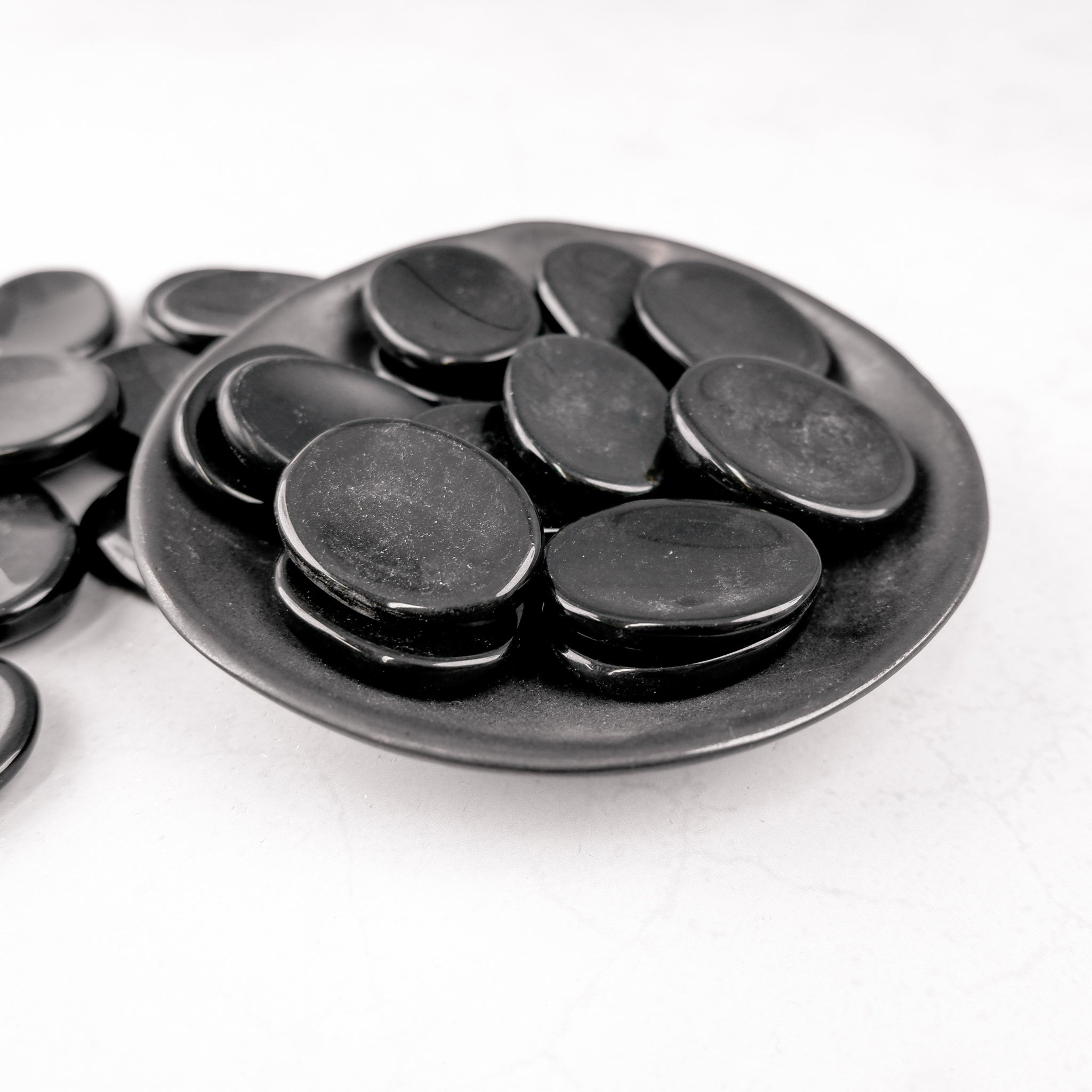 Black Jasper worry stone from Noctis Studio, smooth polished gemstone with natural black and gray patterns, handheld healing tool.