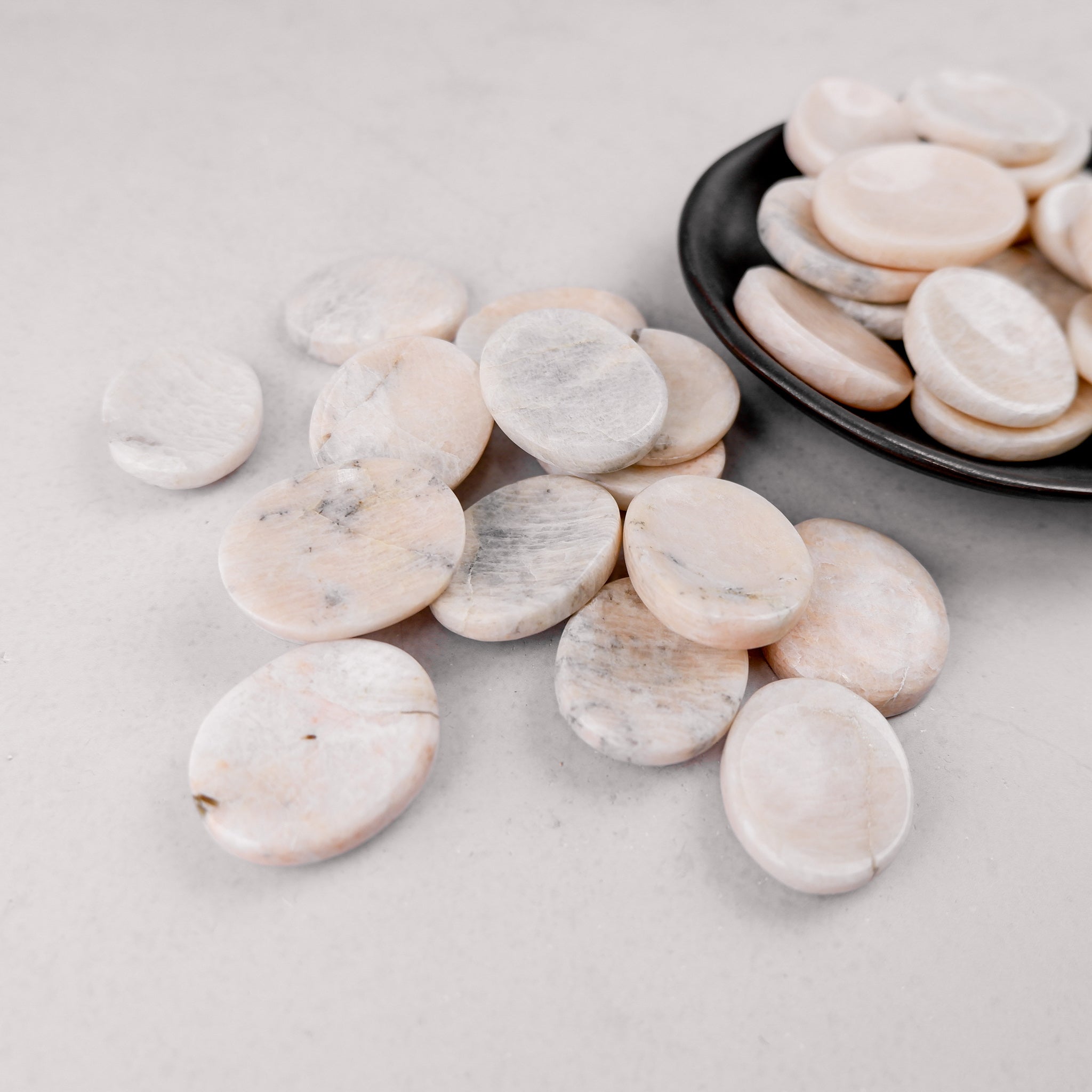 Cream moonstone worry stone from Noctis Studio, smooth polished gemstone with gentle cream and iridescent hues for calming use.