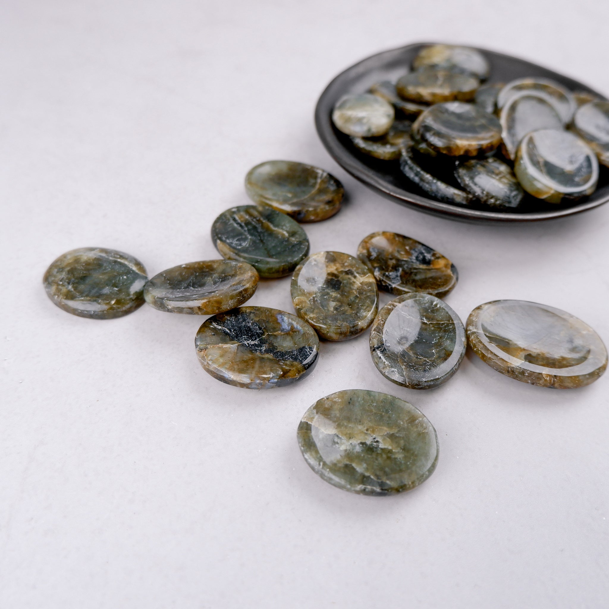 Labradorite worry stone from Noctis Studio, smooth polished gemstone for meditation and stress relief, showing iridescent colors.