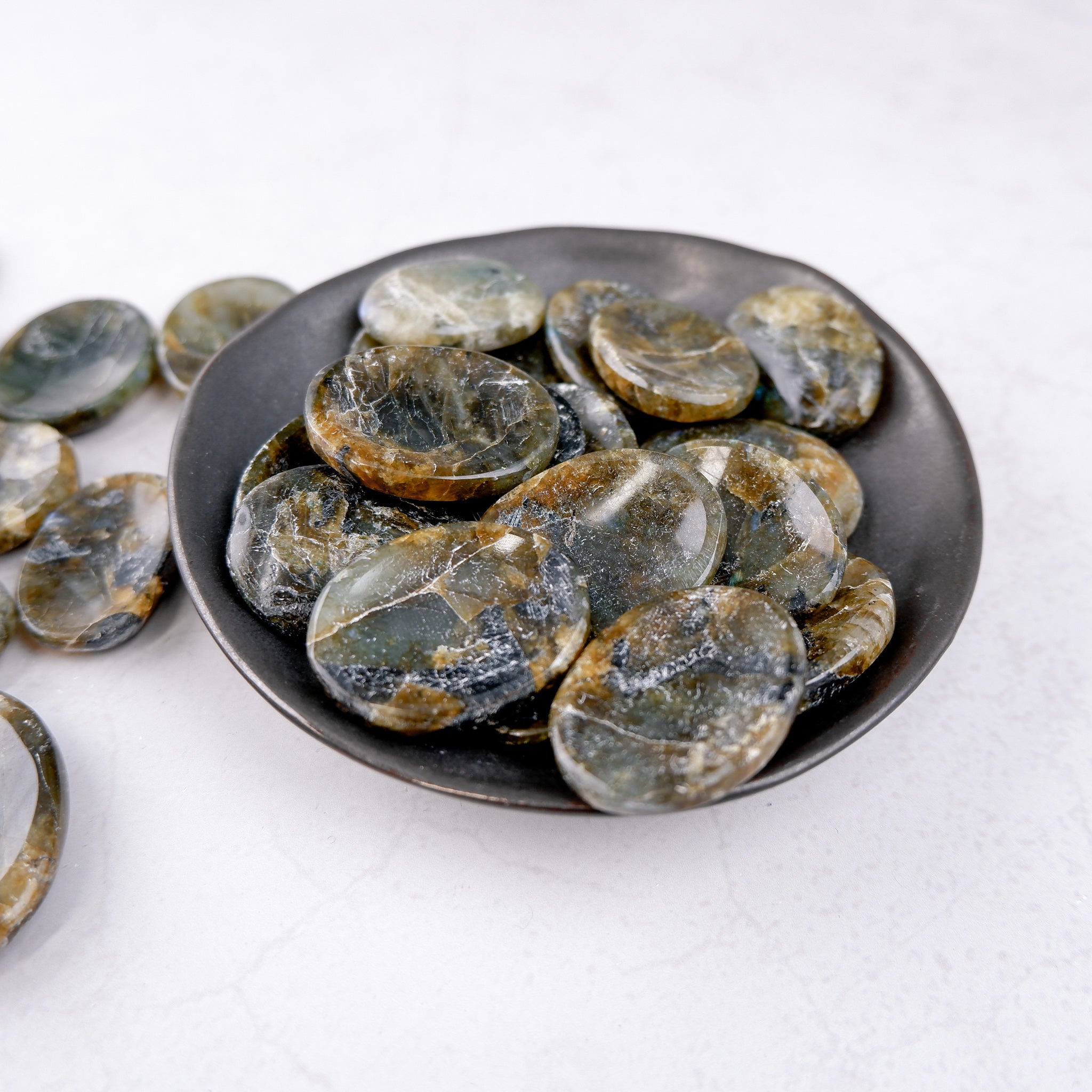 Labradorite worry stone from Noctis Studio showing iridescent blue and green hues, smooth polished gemstone for stress relief.