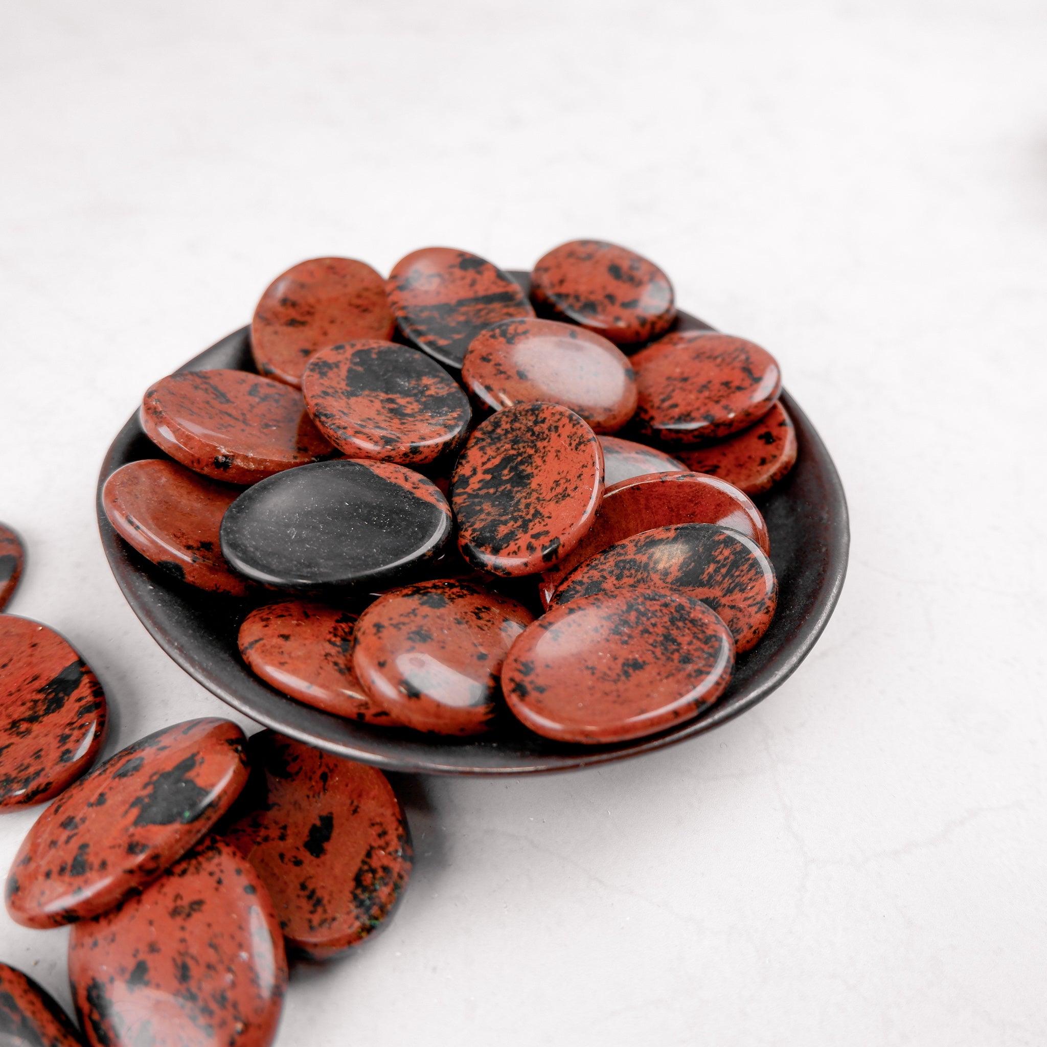 Mahogany Obsidian worry stone from Noctis Studio showing smooth, polished mahogany-colored obsidian with natural patterns.