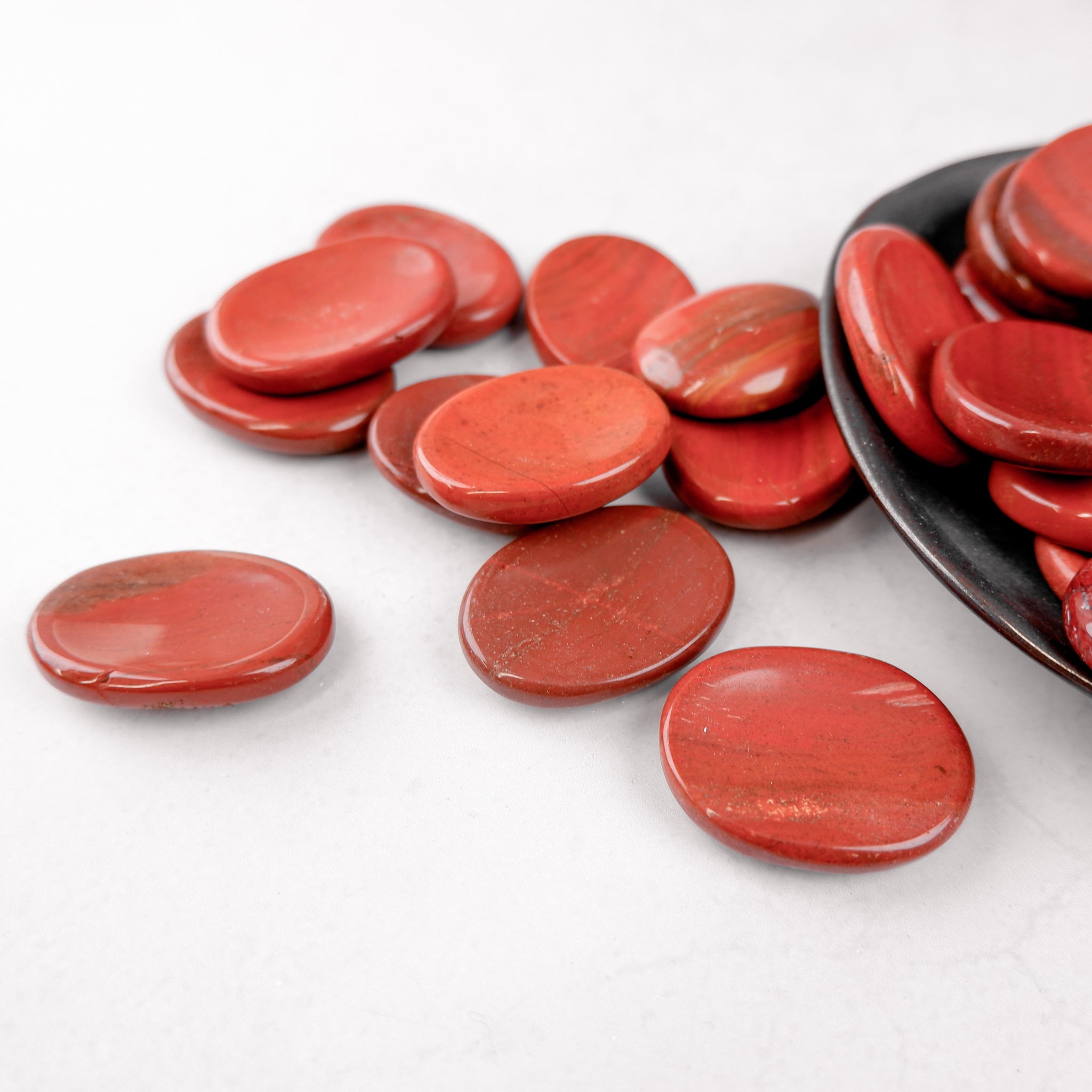 Red Jasper worry stone from Noctis Studio, smooth polished gemstone for stress relief and meditation, shown close-up.