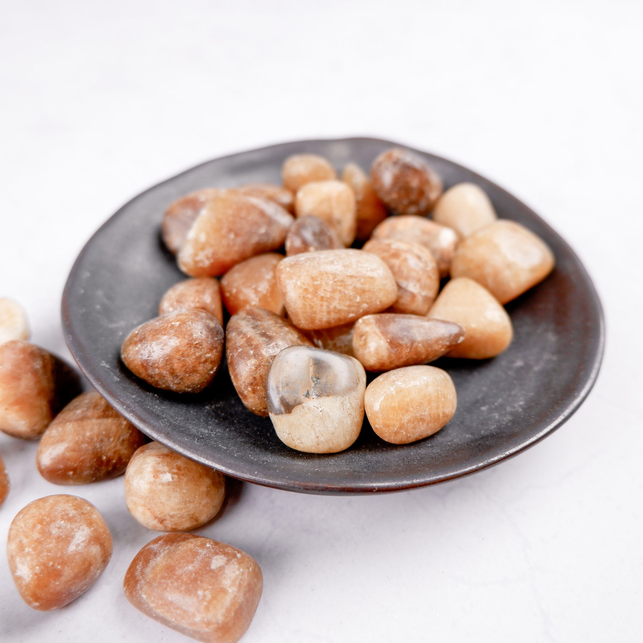 Noctis Studio Aragonite tumble stone with natural beige and white mineral formations on a smooth surface.