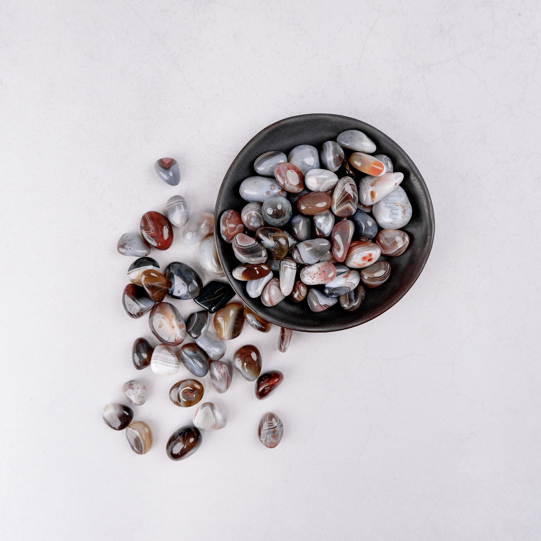 Botswana Agate tumble stone from Noctis Studio, showing smooth, polished mineral with unique banding and natural earthy tones.