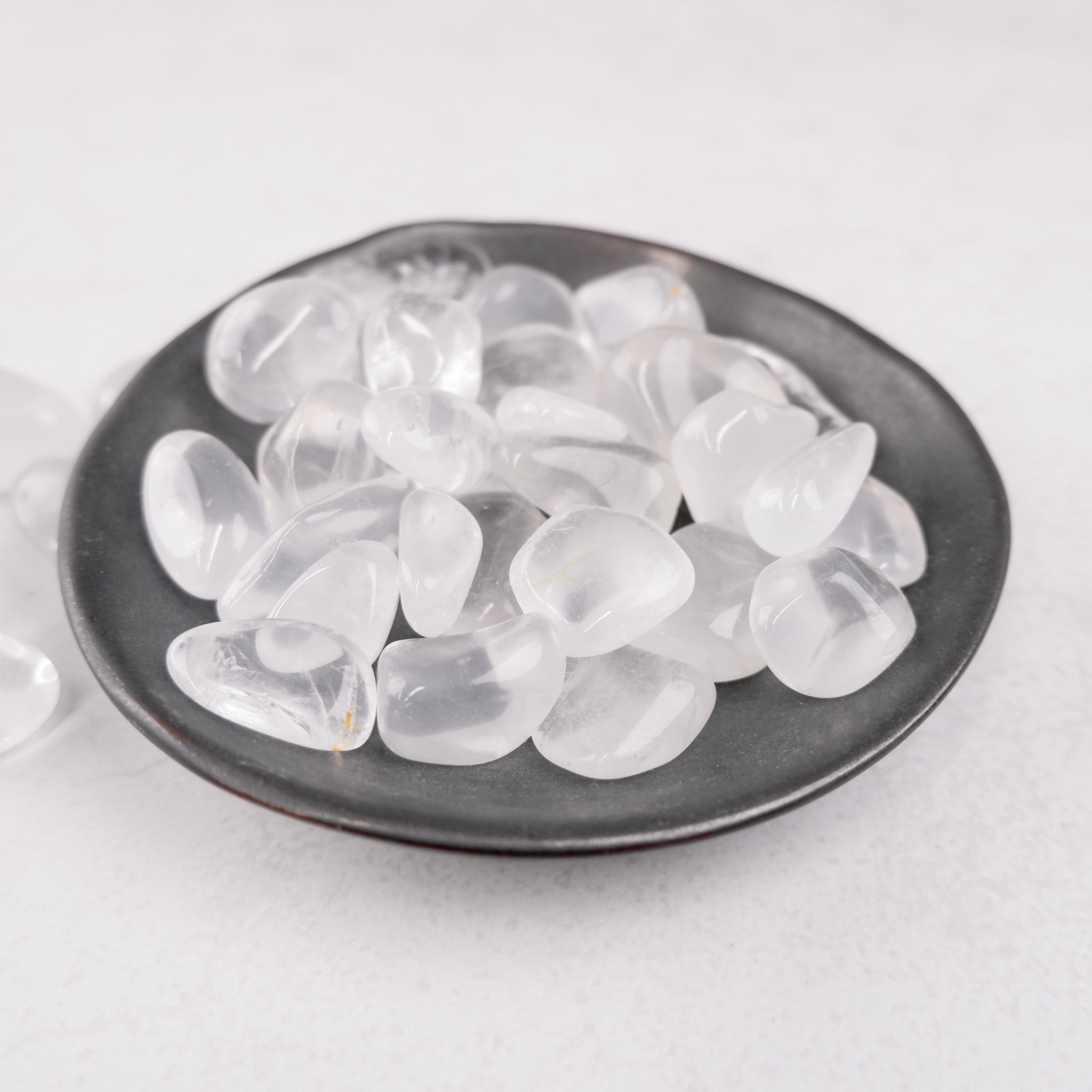 Girasol tumble stone from Noctis Studio, showing a polished, semi-transparent mineral with soft yellow and white hues.