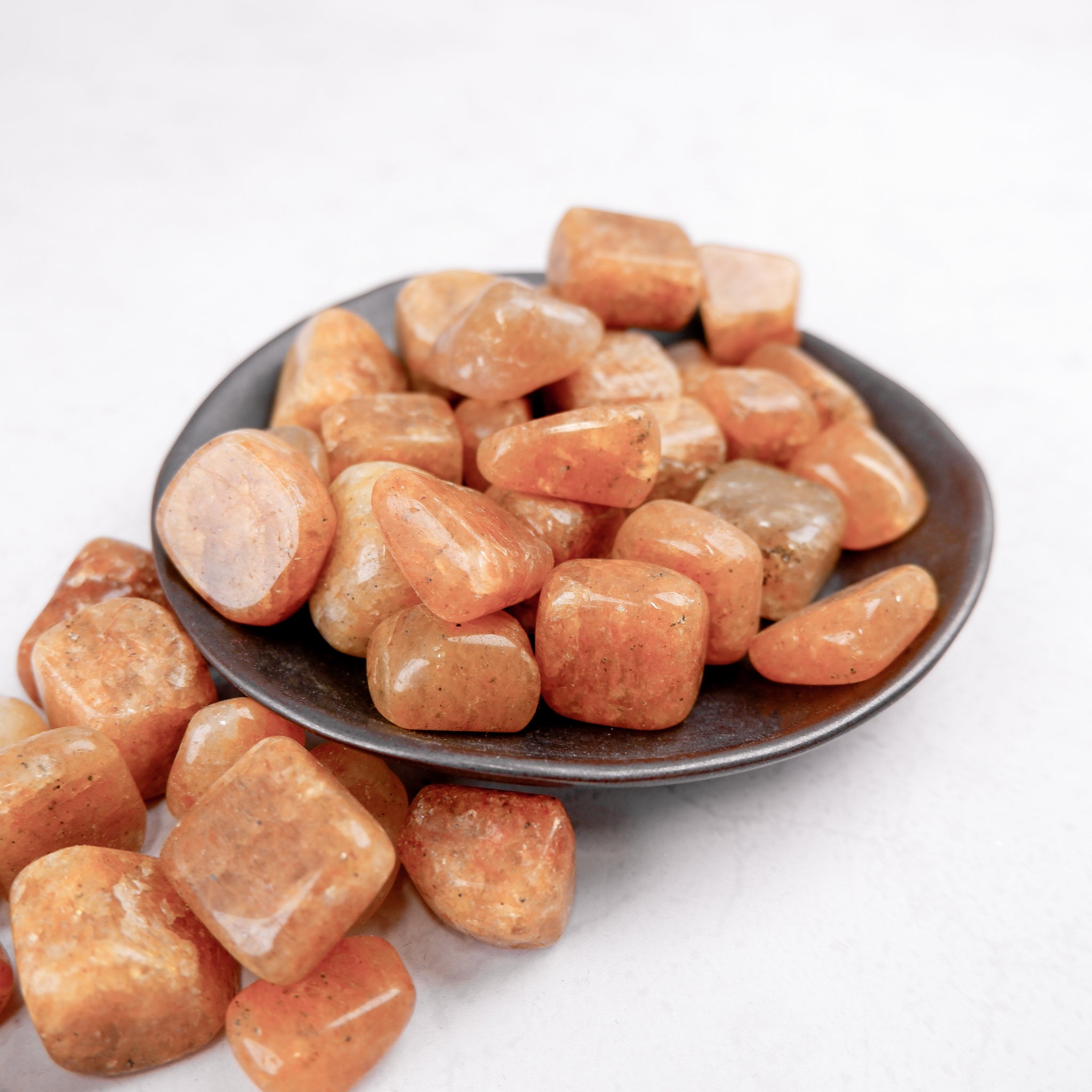 Golden Quartz tumble stone from Noctis Studio, polished smooth gemstone with vibrant golden color and natural crystal patterns.