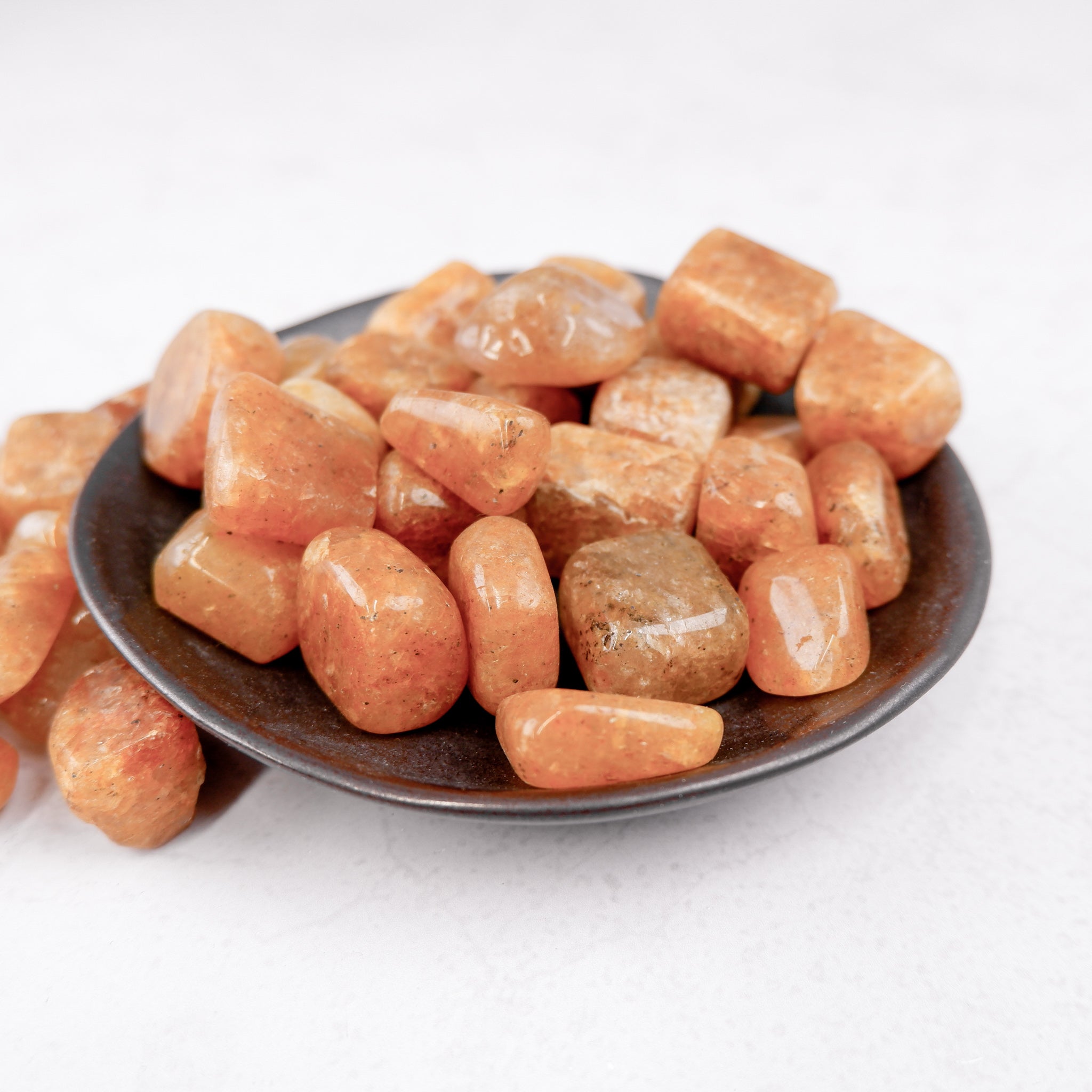 Golden Quartz tumble stone from Noctis Studio showing a polished, golden-colored gemstone with smooth, rounded surface.