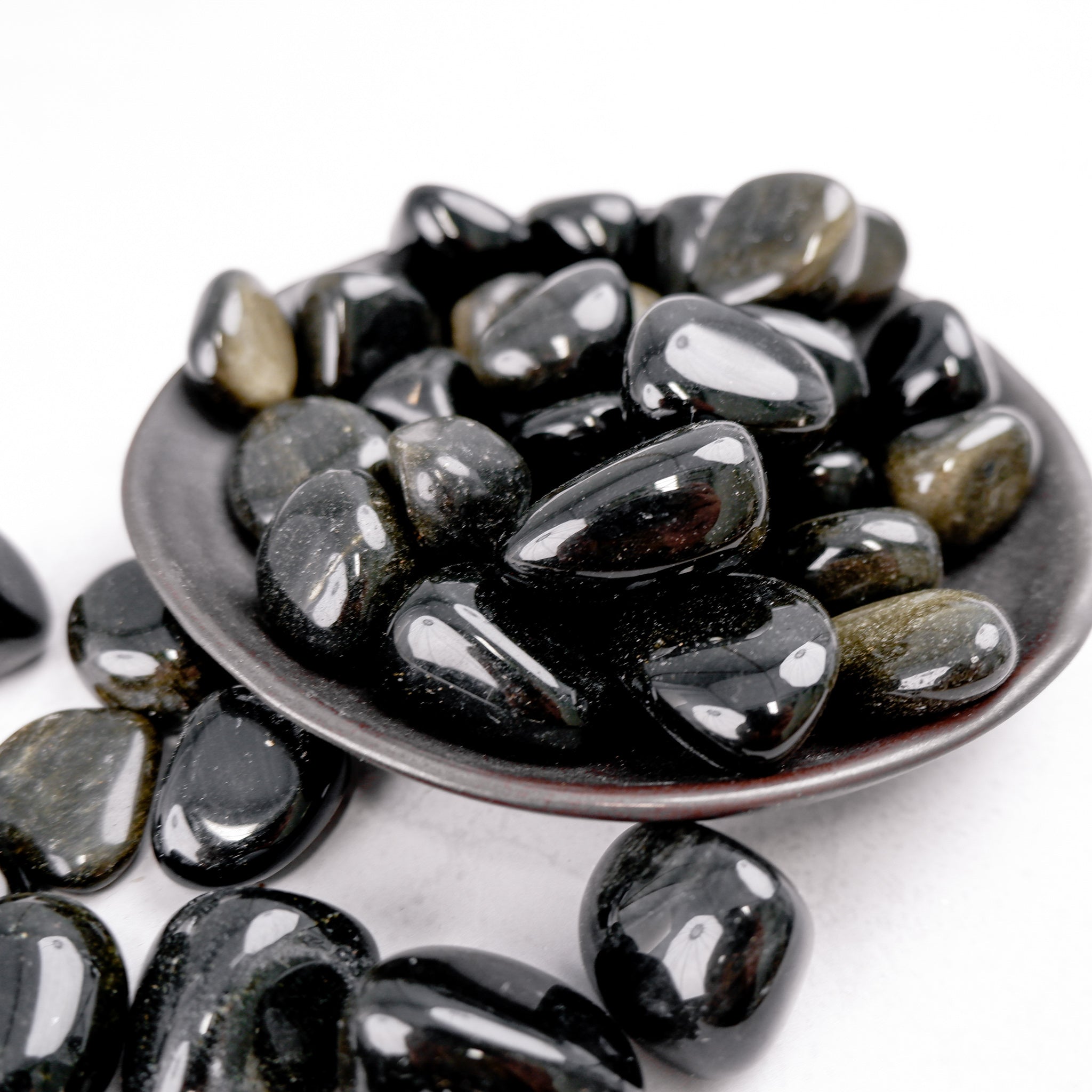 Golden Sheen Obsidian tumble stone from Noctis Studio, showcasing polished black stone with golden iridescent sheen.