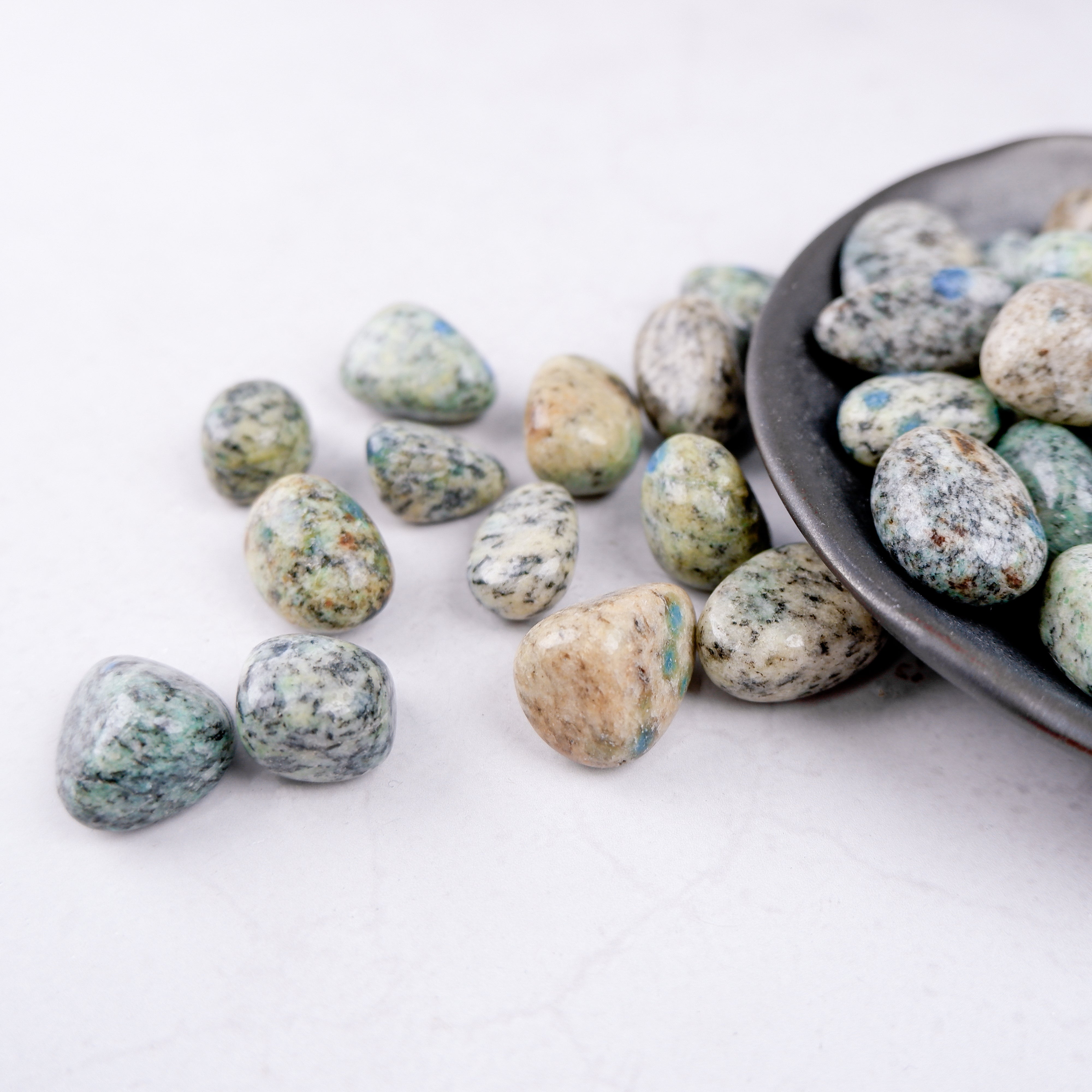 Noctis Studio K2 Tumble Stone displaying a polished, smooth mineral gemstone with vibrant blue and green hues.