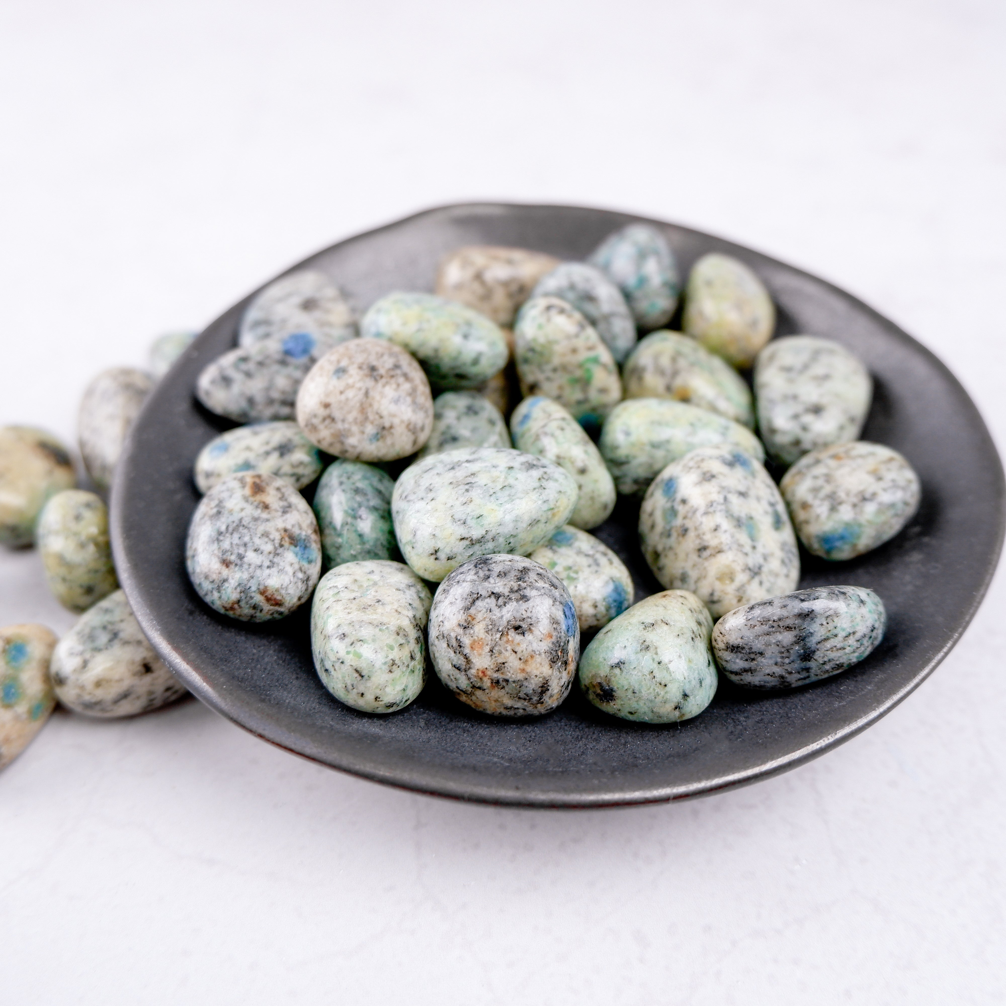 Noctis Studio K2 Tumble Stone showcasing smooth, polished blue-green mineral with natural patterns and vibrant coloration.