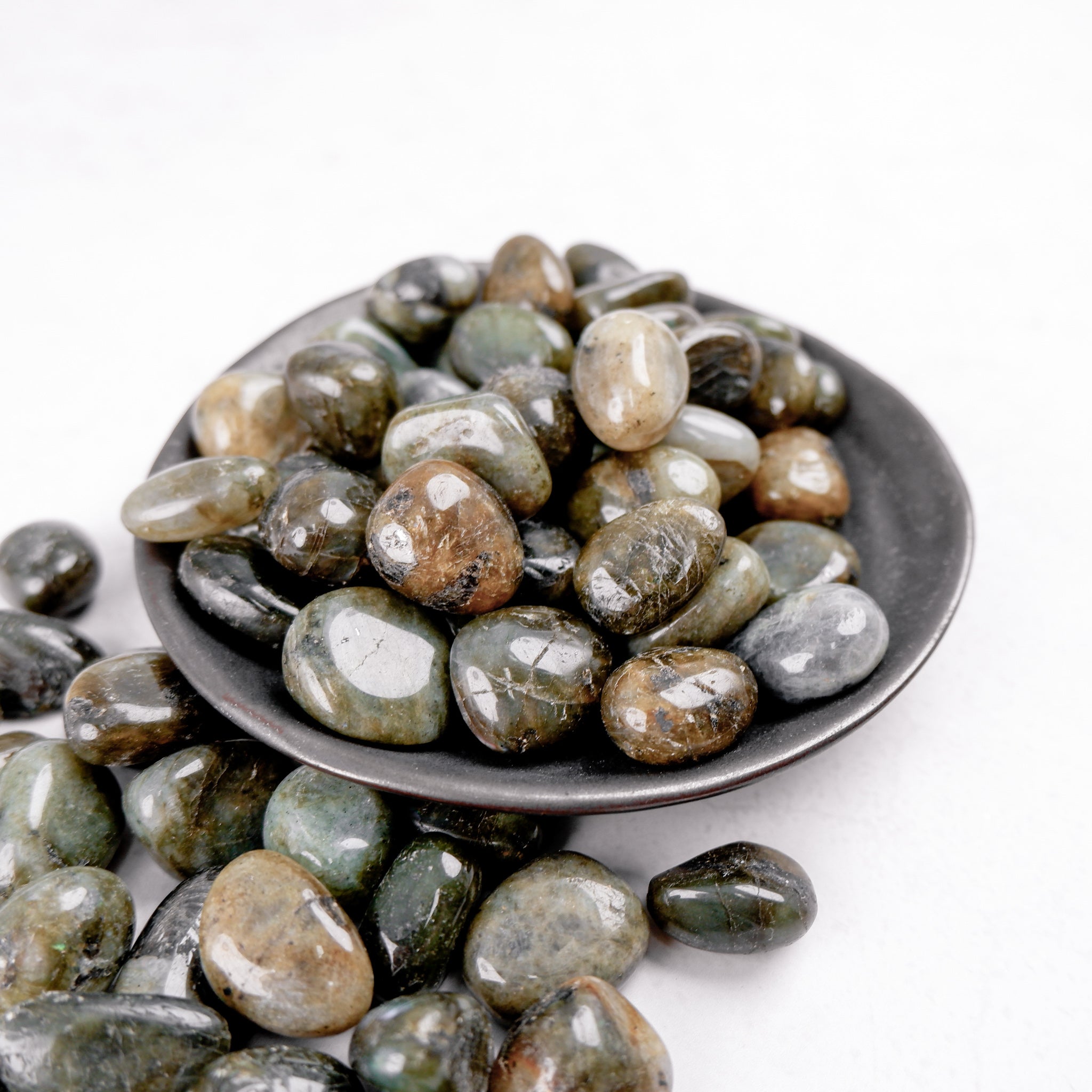 Labradorite tumble stone from Noctis Studio showing iridescent blue and green flashes in a smooth polished finish.