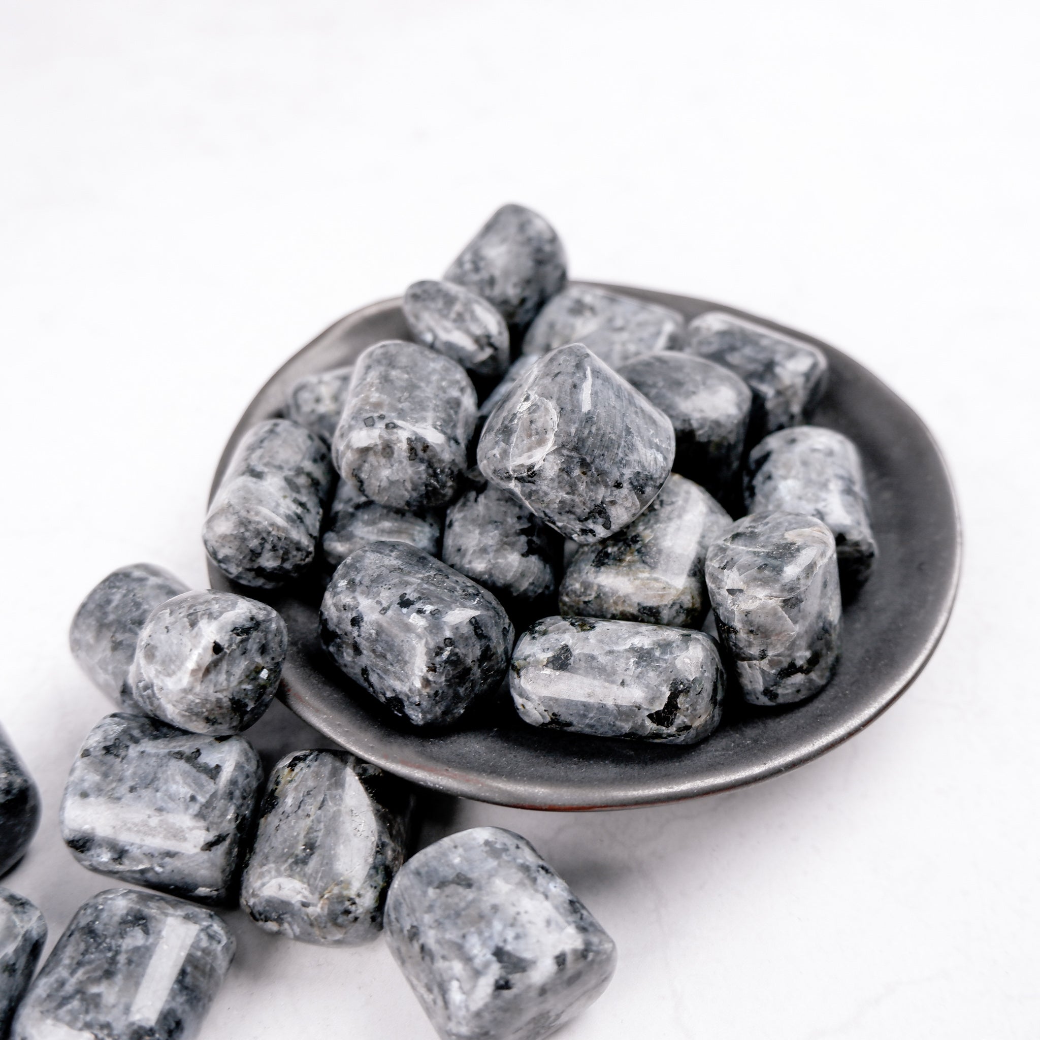 Larvikite tumble stone from Noctis Studio, polished mineral with dark blue and silver shimmer, showcasing its natural crystalline surface.