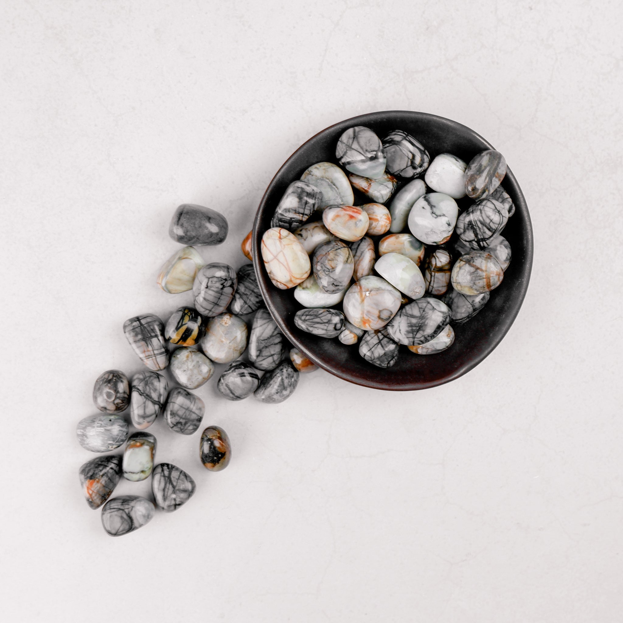 Noctis Studio Picasso Jasper tumble stone with vibrant, swirling patterns and earthy colors, showcasing natural mineral beauty.