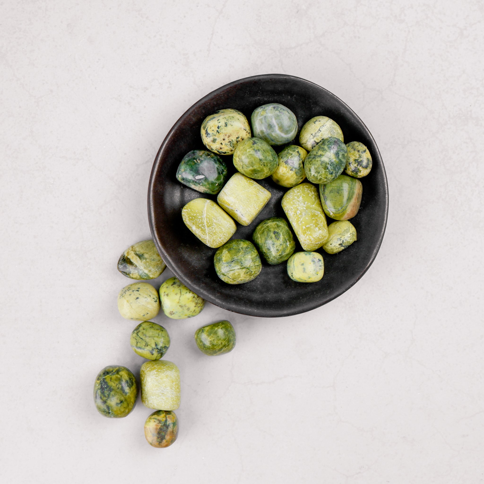 Noctis Studio Serpentine Tumble Stone showing smooth, polished green gemstone with natural patterns and rounded shape.