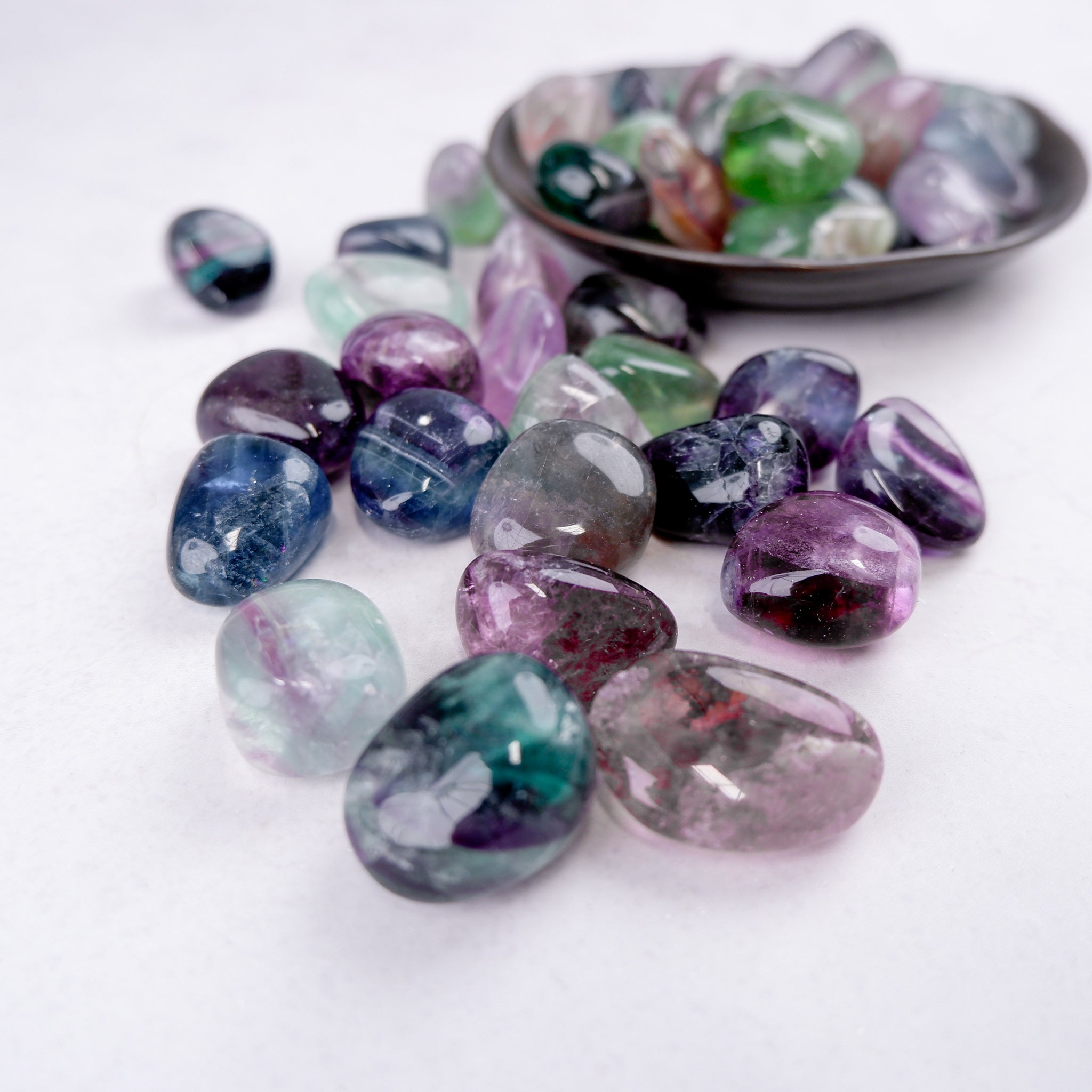 Noctis Studio fluorite tumble stone with vibrant purple and green hues, polished and smooth for crystal healing and decorative use.