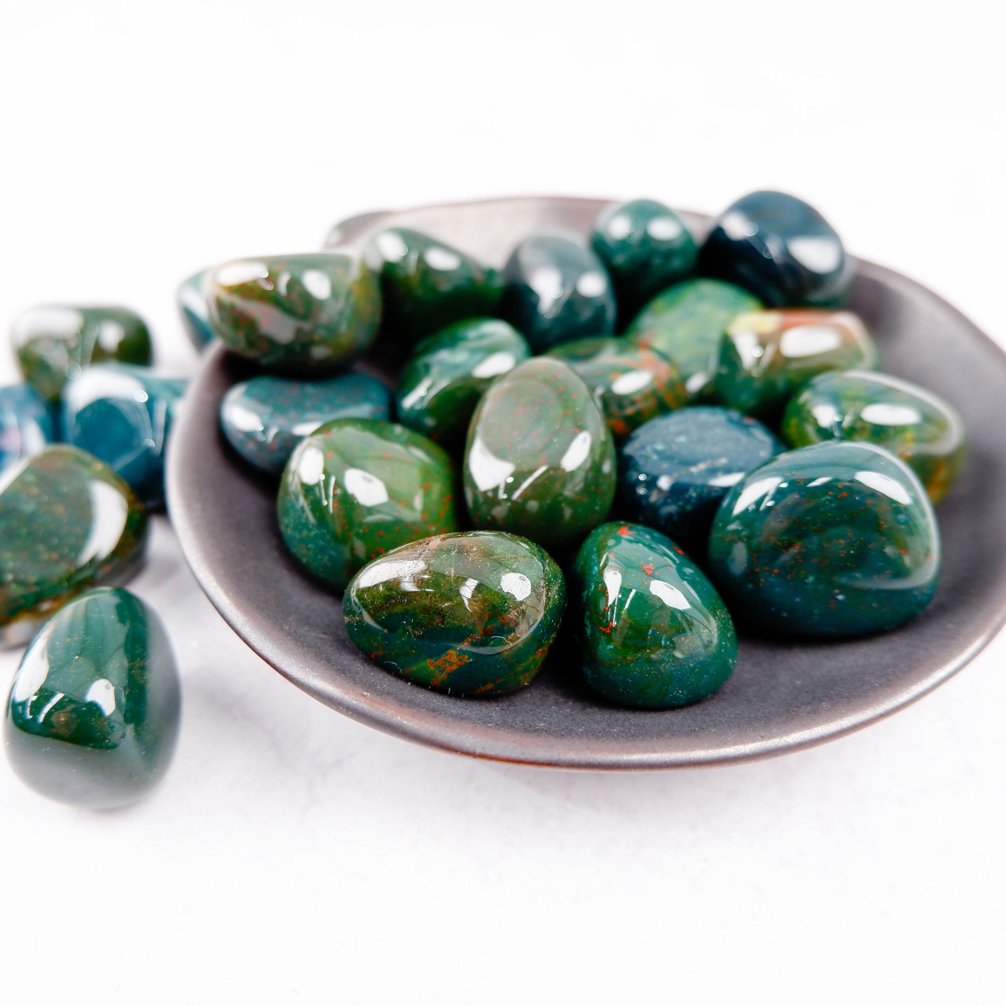 Bloodstone tumble stone from Noctis Studio showing a polished green and red gemstone with natural patterns.