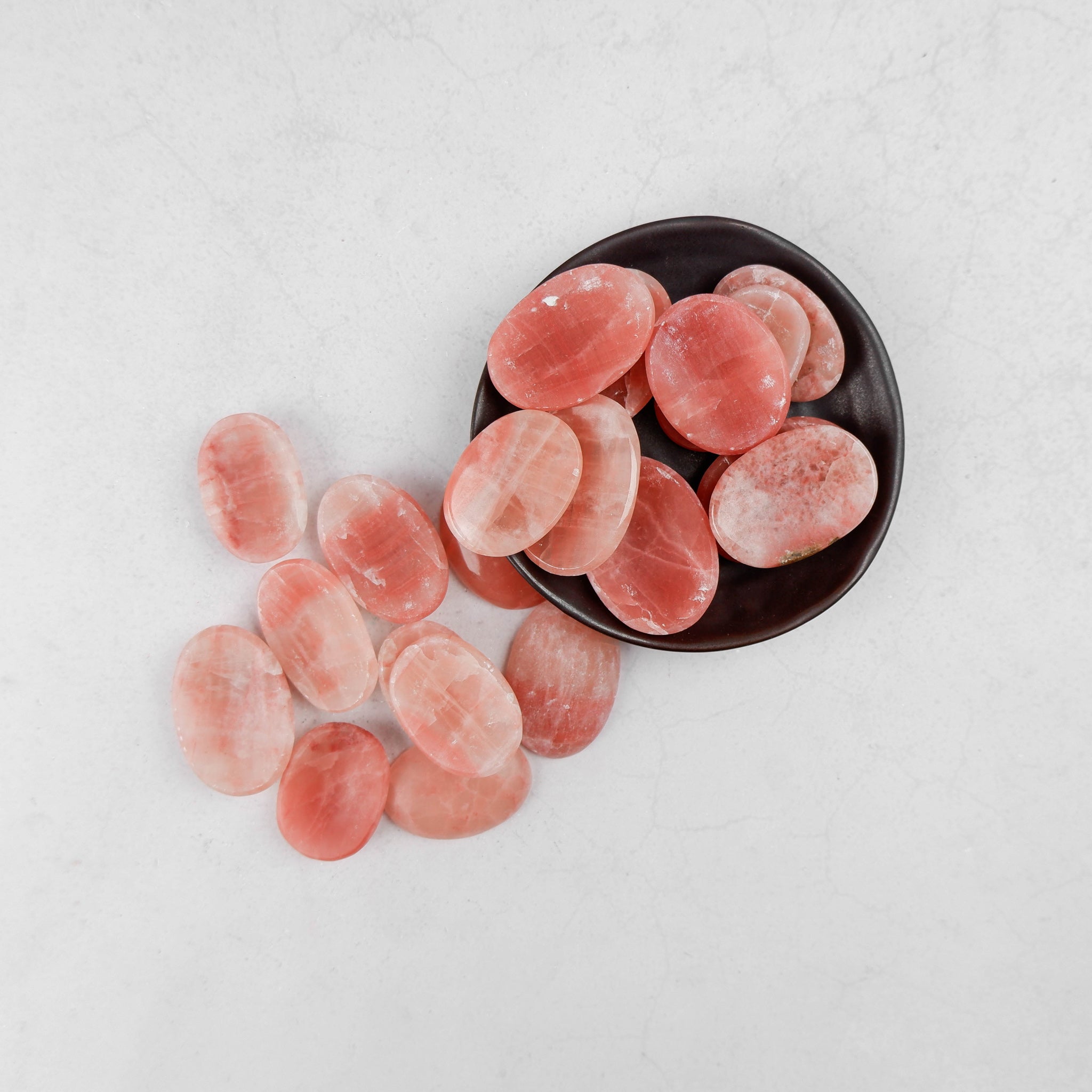 Rose Calcite worry stone from Noctis Studio showing smooth, polished rose-colored gemstone with rounded shape and gentle surface.