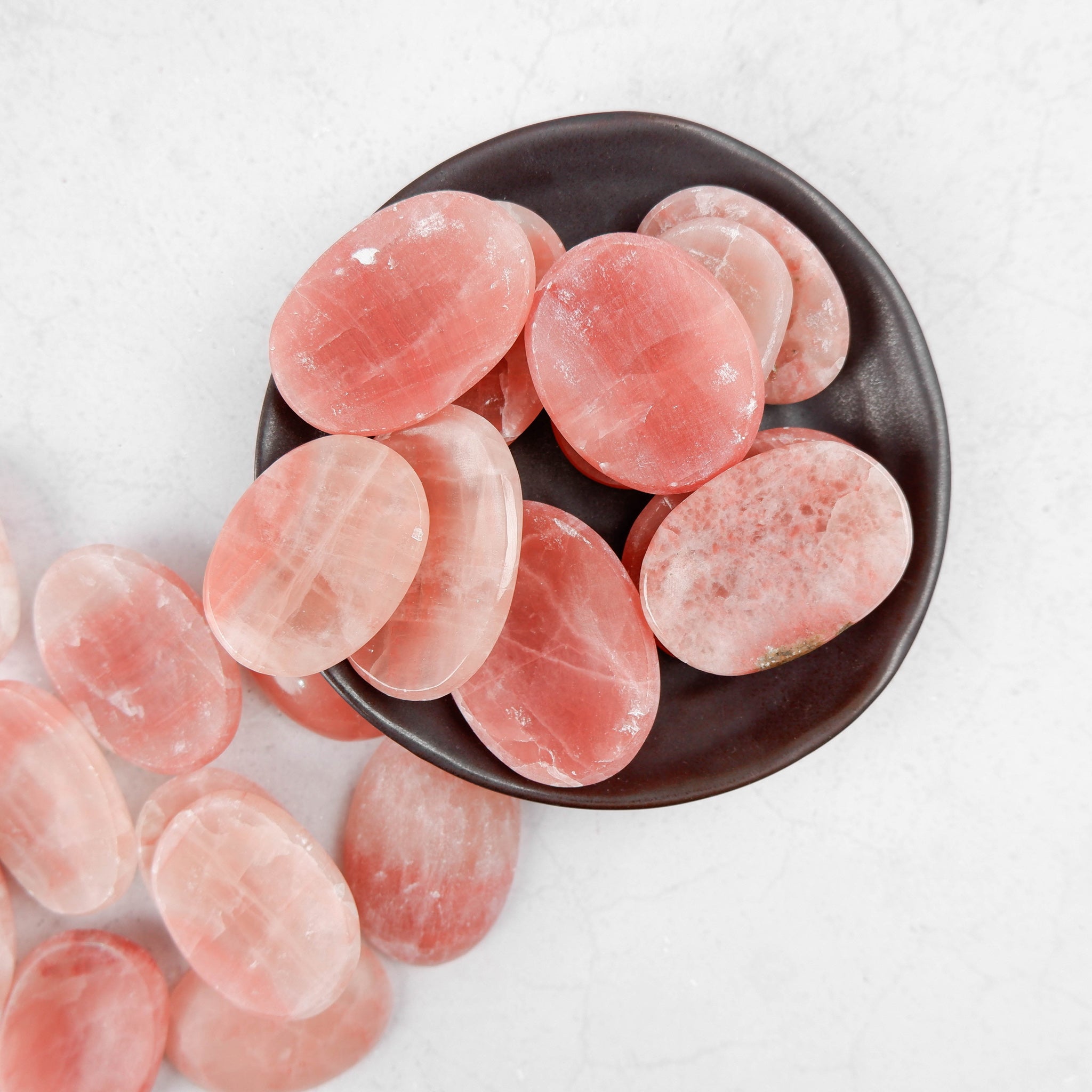 Rose Calcite worry stone by Noctis Studio, smooth polished gemstone for stress relief, with soft pink hue and rounded shape.