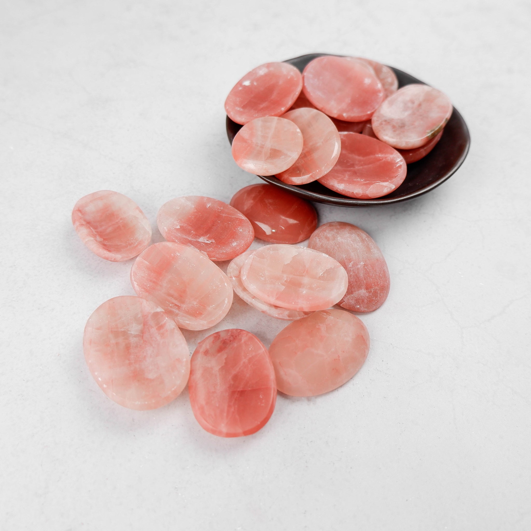 Rose Calcite worry stone by Noctis Studio, smooth polished gemstone with soft pink hues and rounded shape for calming stress relief.