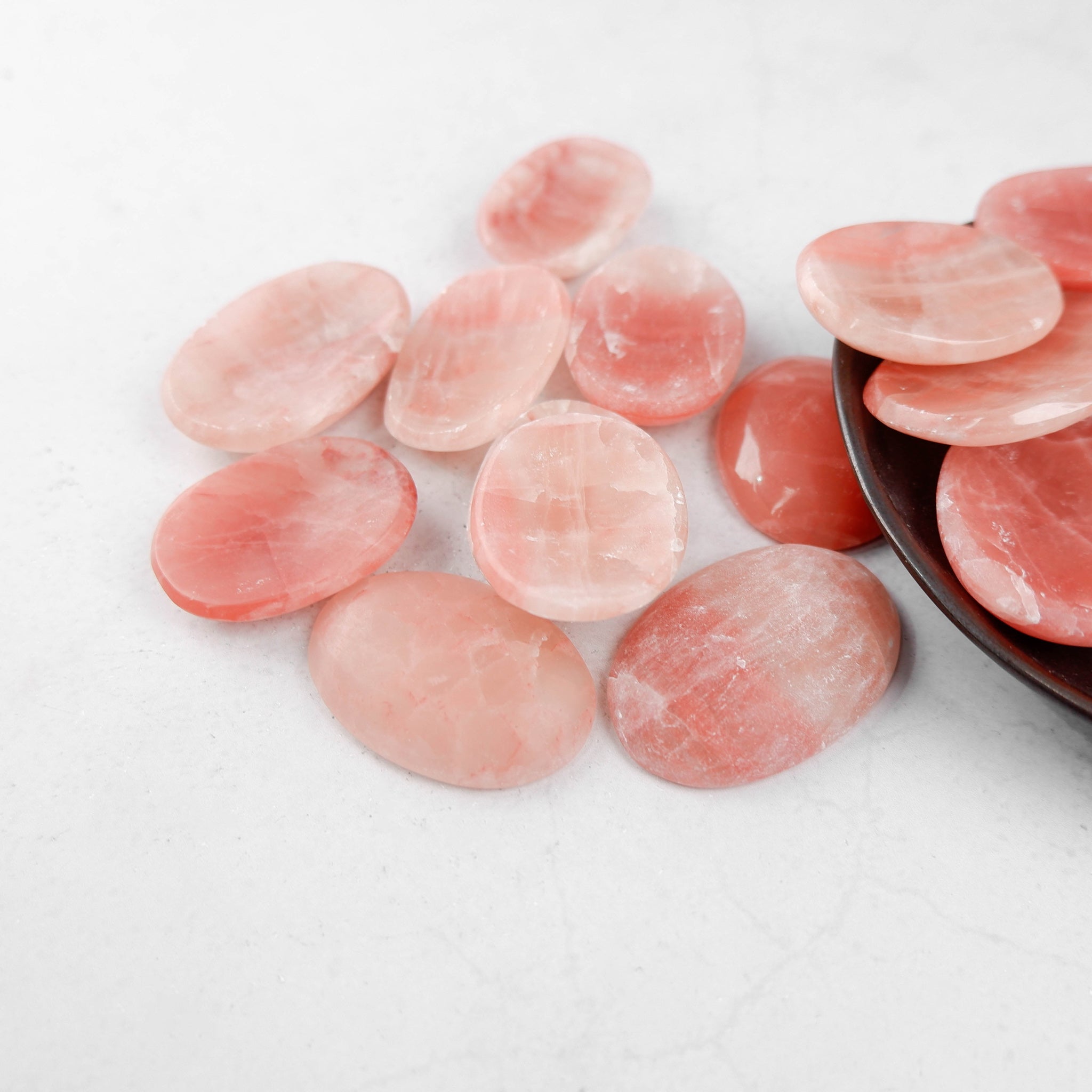Rose Calcite worry stone from Noctis Studio, smooth oval-shaped gemstone with soft pink hue and polished surface.