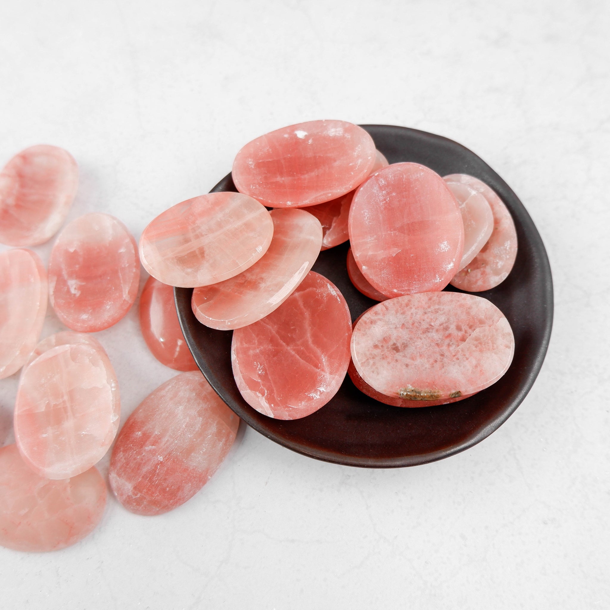 Rose calcite worry stone from Noctis Studio with smooth, polished surface and soft pink hue for calming stress relief.