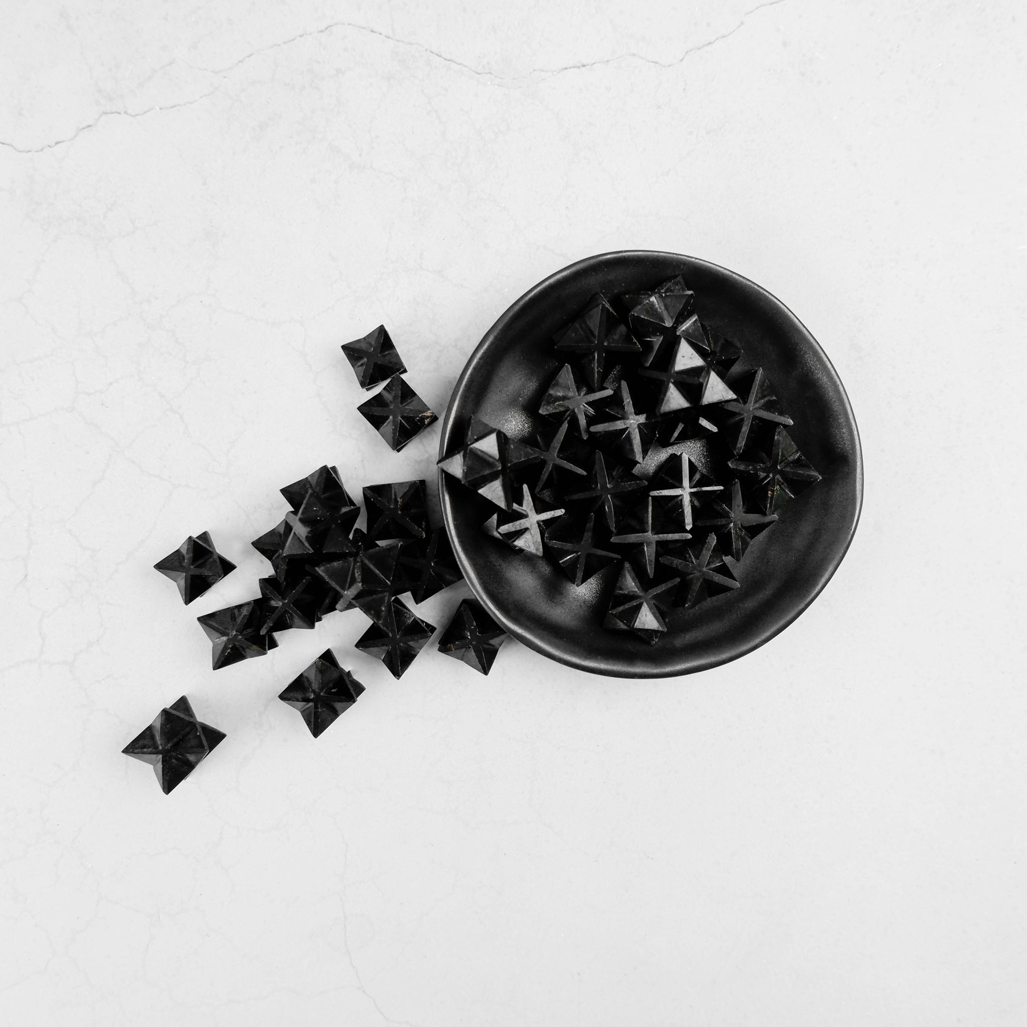 Black Tourmaline Star by Noctis Studio, a polished star-shaped crystal with a smooth, glossy black surface and natural mineral details.