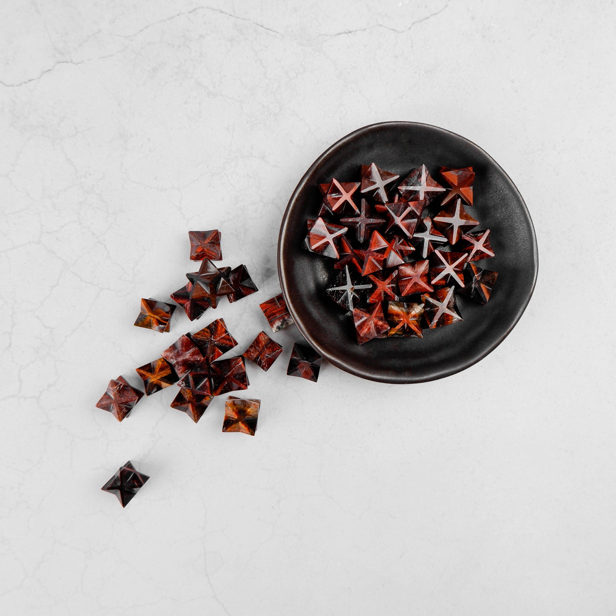 Red Tigers Eye Star from Noctis Studio featuring a polished star-shaped gemstone with vibrant red and brown tones.