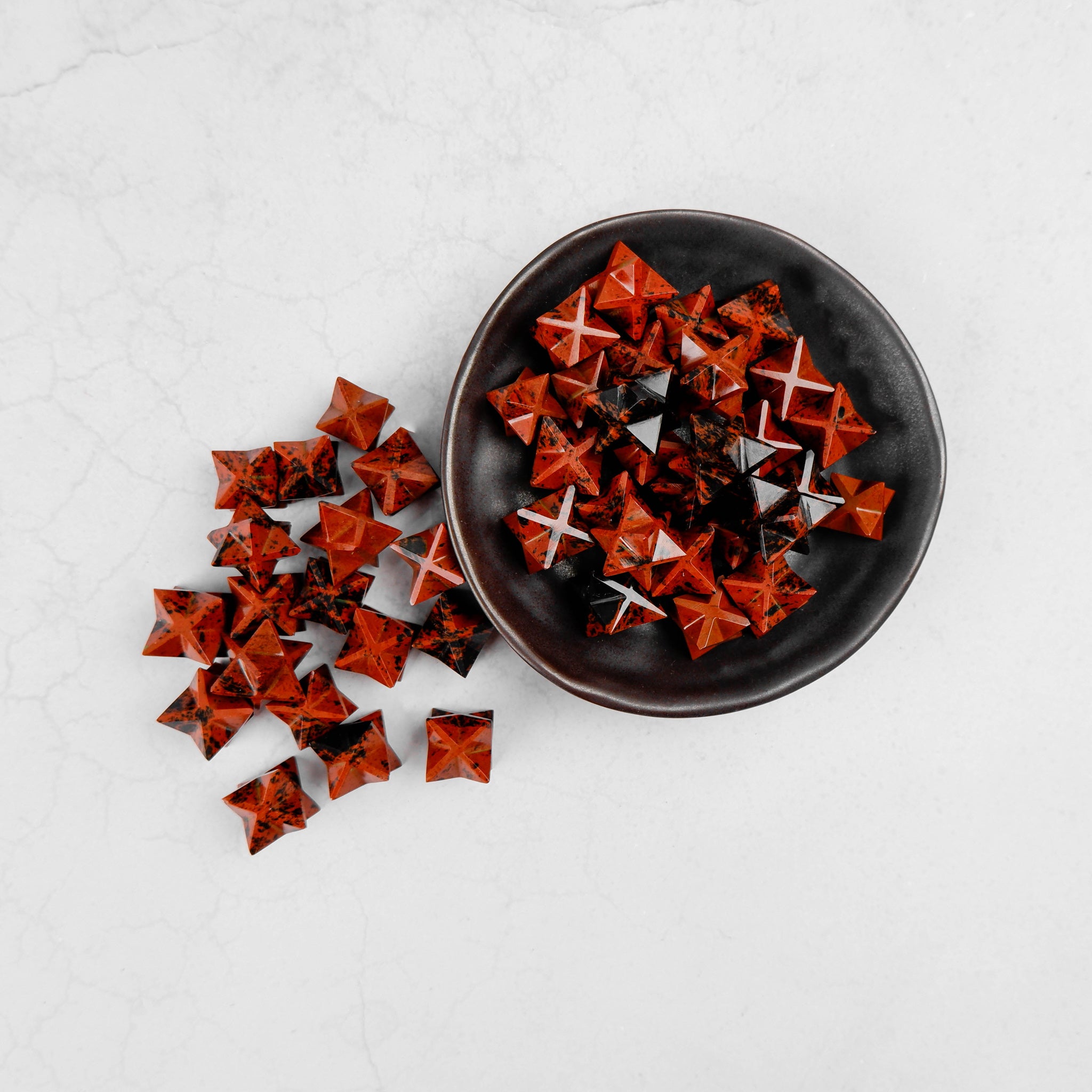 Noctis Studio Mahogany Obsidian star sculpture featuring a polished, glossy dark red and black gemstone star with natural patterns.