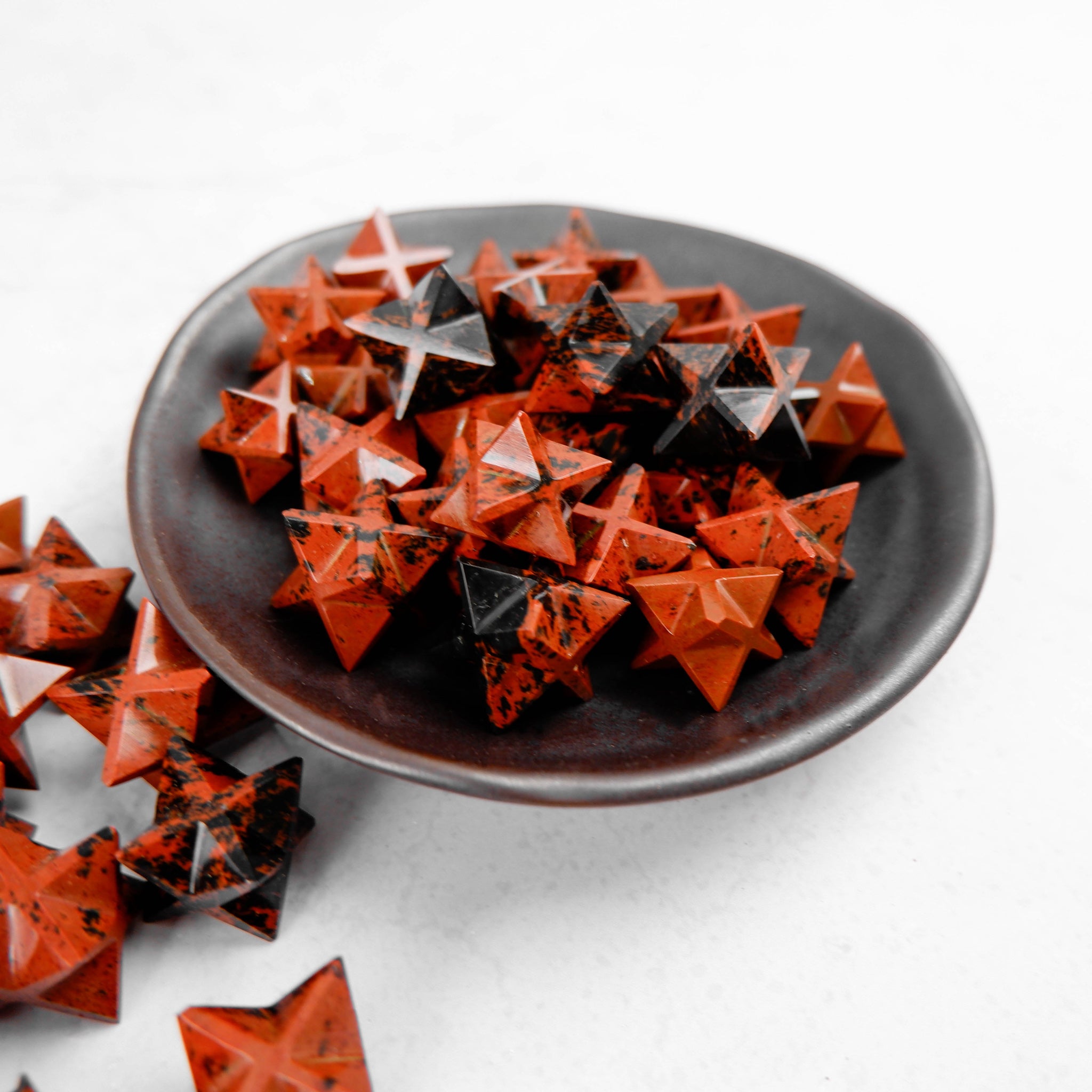 Dark mahogany obsidian star sculpture from Noctis Studio, featuring a polished, five-pointed star with natural stone textures.