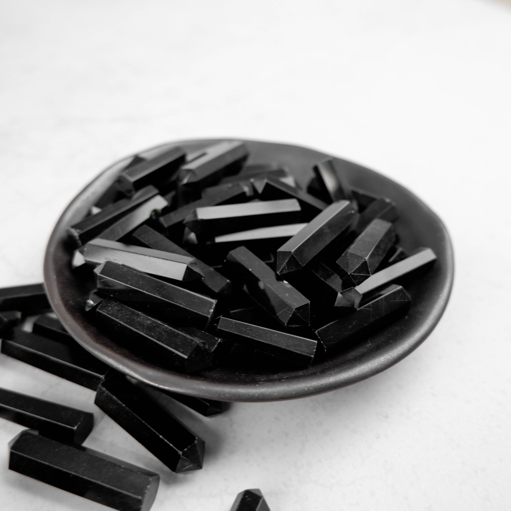 Obsidian single gridding point from Noctis Studio, a black tool with a pointed tip used for precise gridding work.