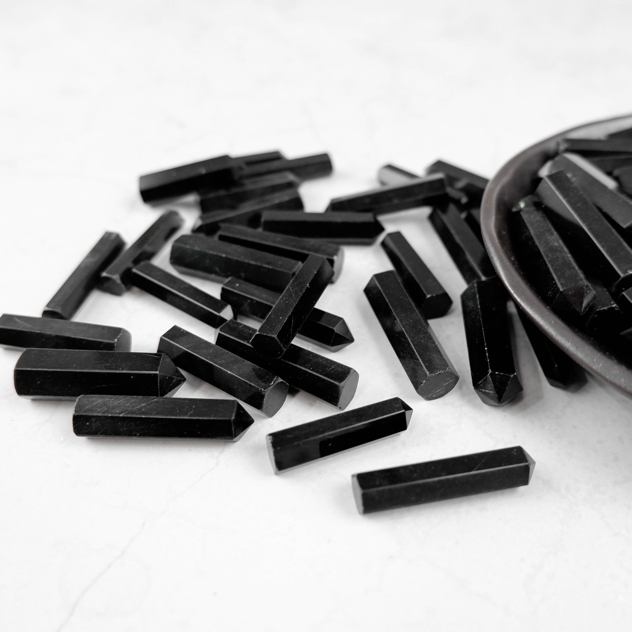 Obsidian single gridding point by Noctis Studio, a black stone tool with a pointed tip for precise gridding applications.