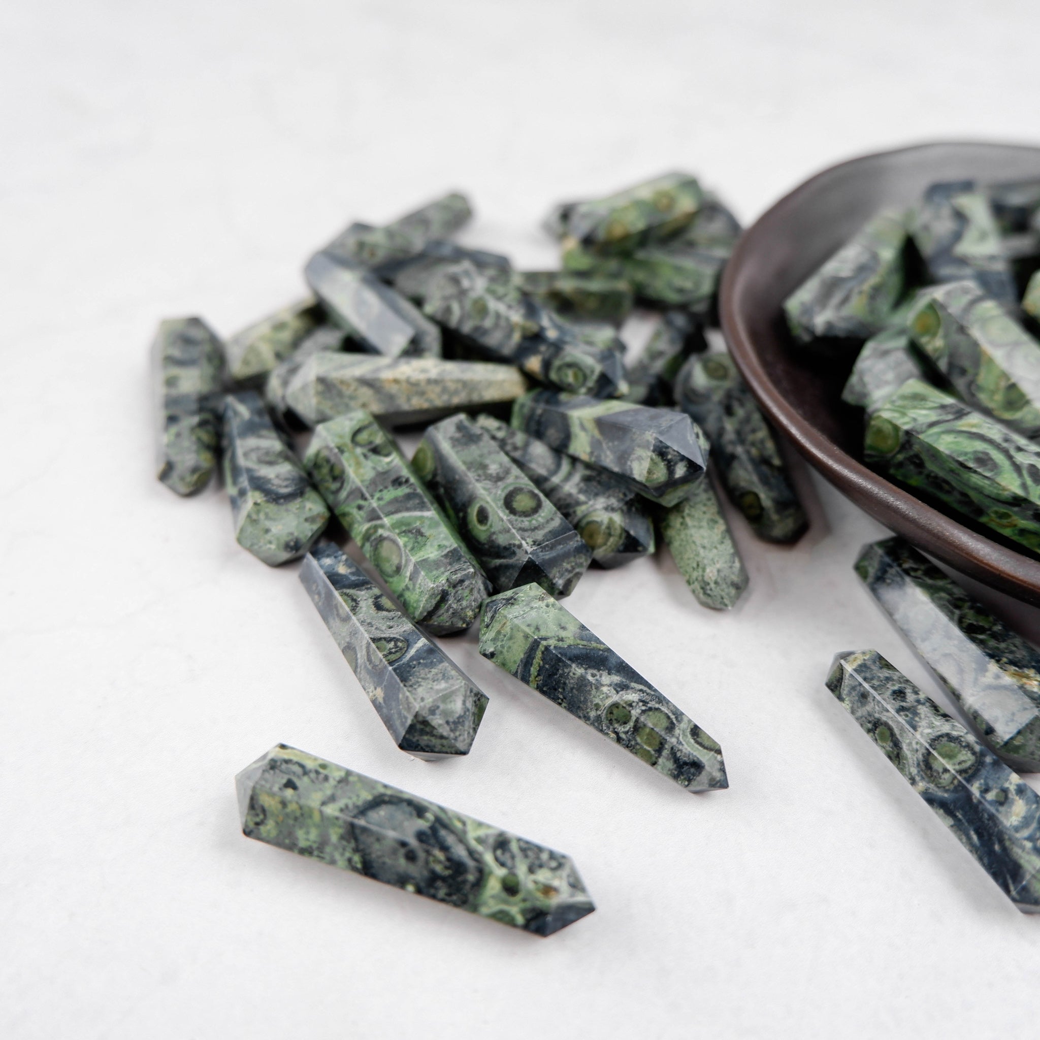 Kambaba Jasper double gridding point from Noctis Studio, polished stone with green and black swirling patterns.