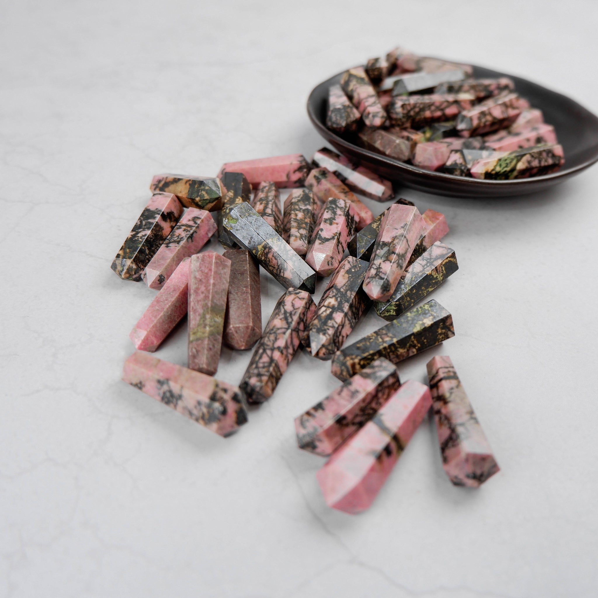 Rhodonite double gridding point sculpture by Noctis Studio, showcasing polished pink and black stone with pointed tip design.