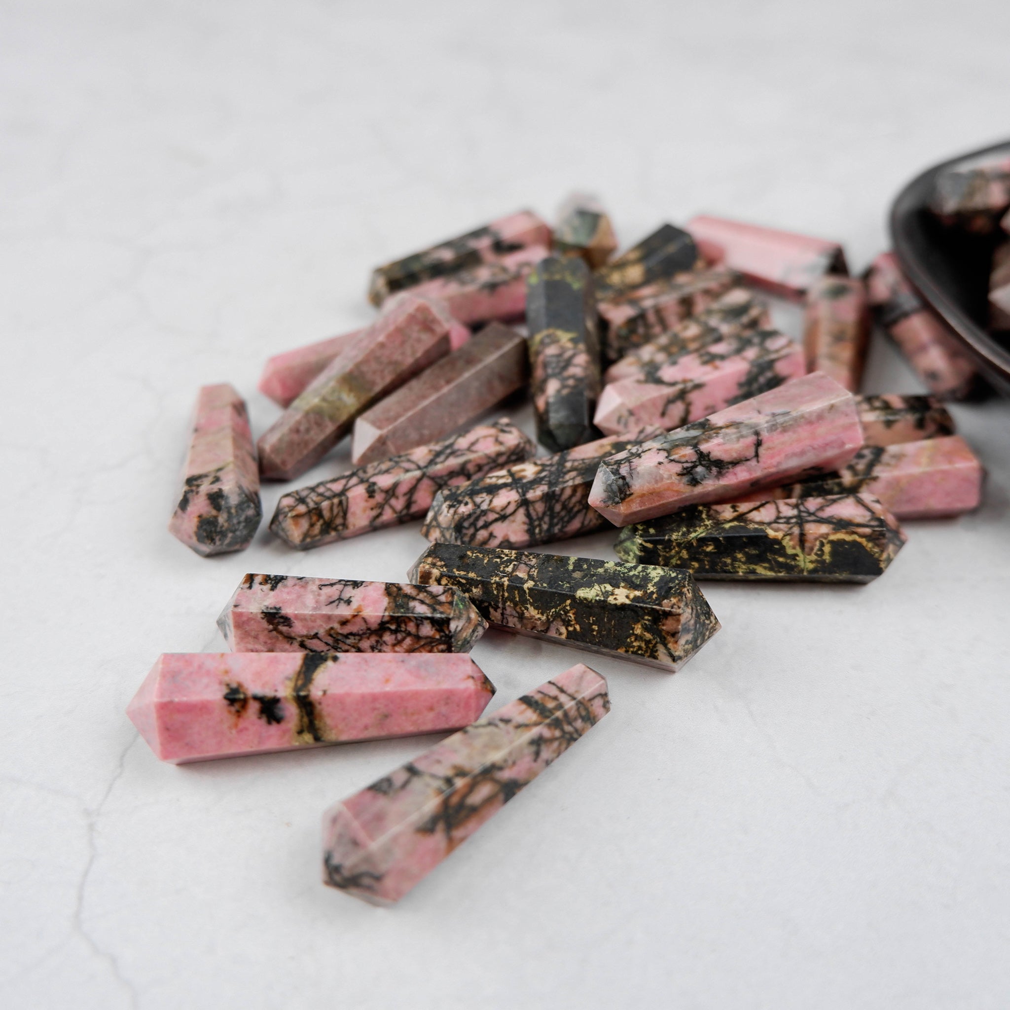 Rhodonite double gridding point from Noctis Studio, featuring a polished pink and black stone with pointed ends for healing and energy work.