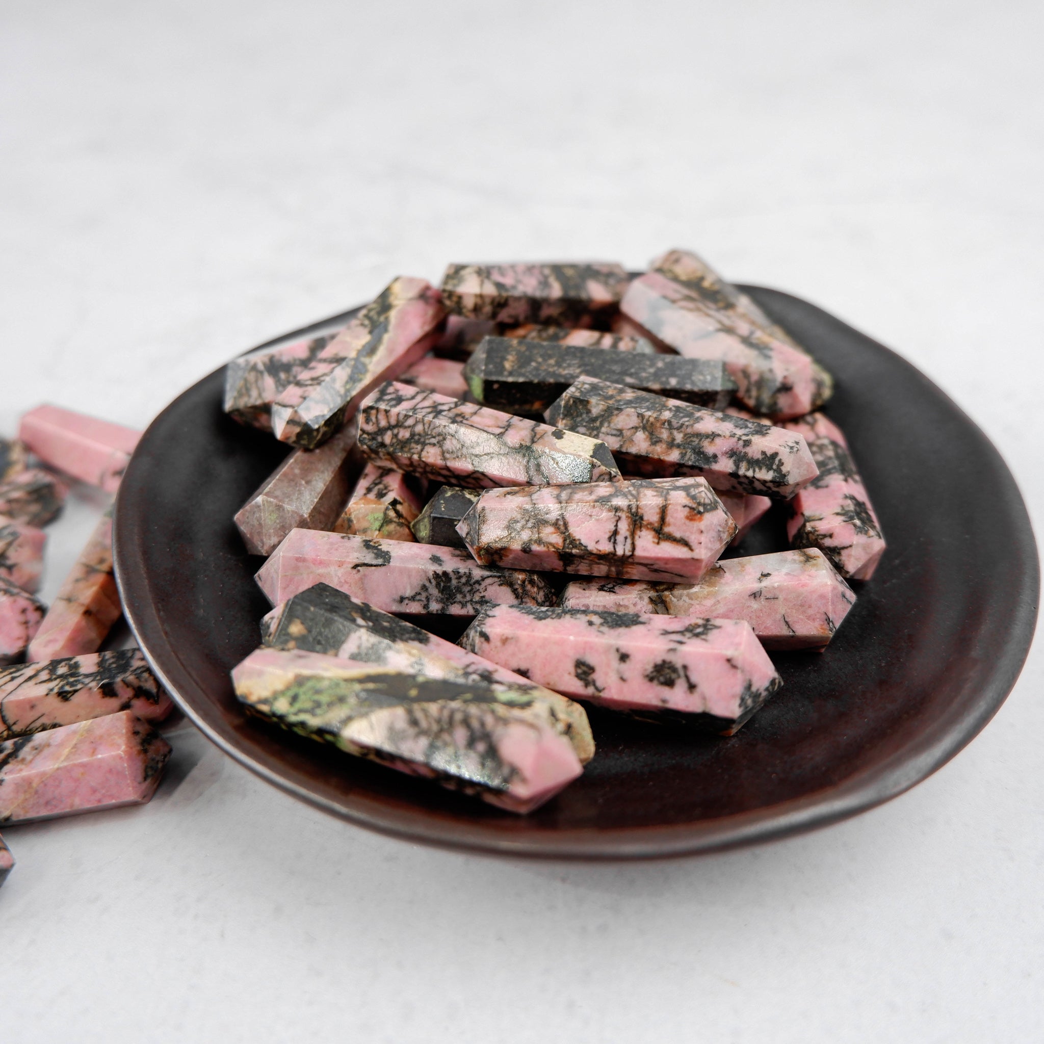 Rhodonite double gridding point from Noctis Studio, featuring polished pink and black stone with pointed tips for crystal healing.
