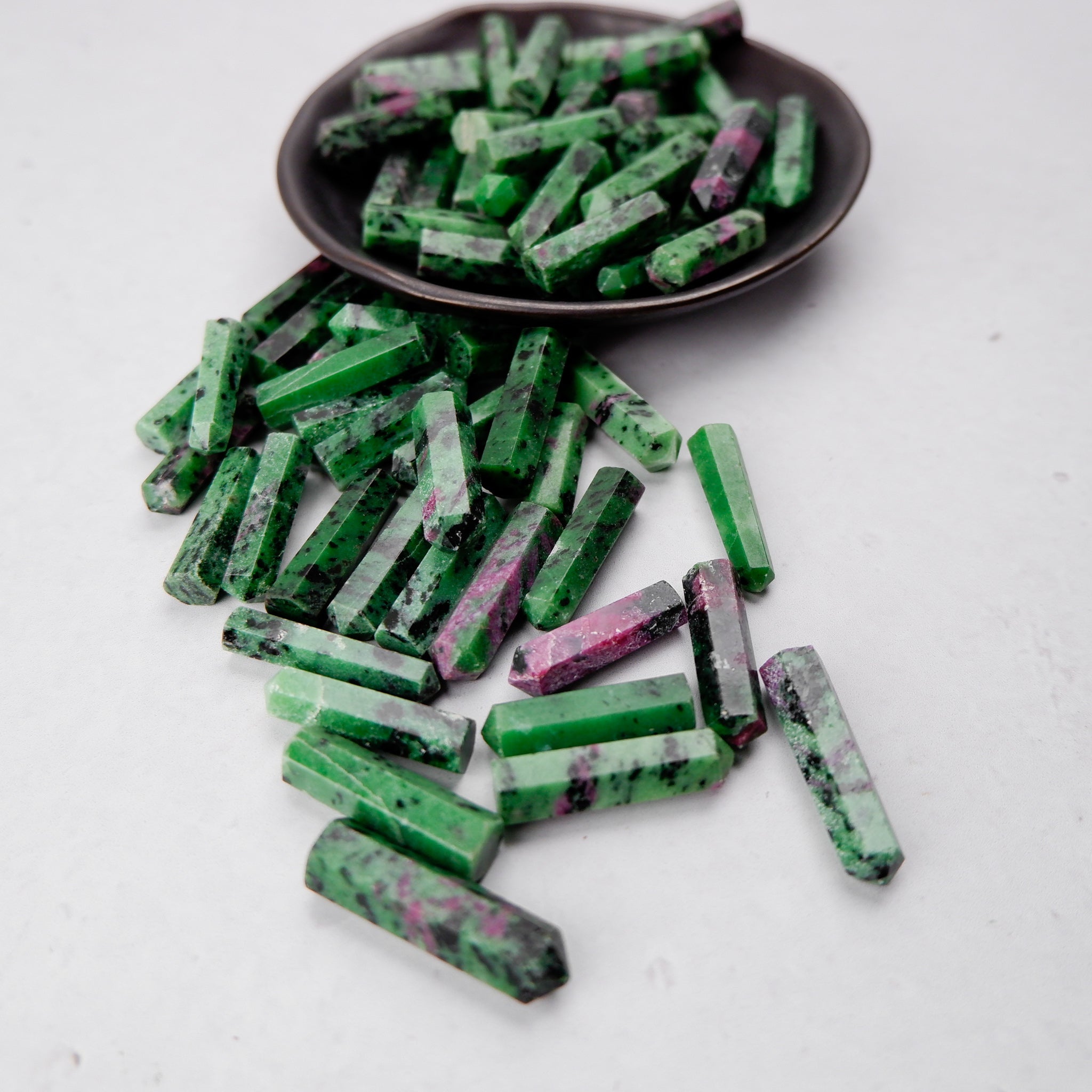 Ruby in Zoisite single gridding point crystal from Noctis Studio, showcasing a polished, pointed gemstone with vibrant red and green hues.