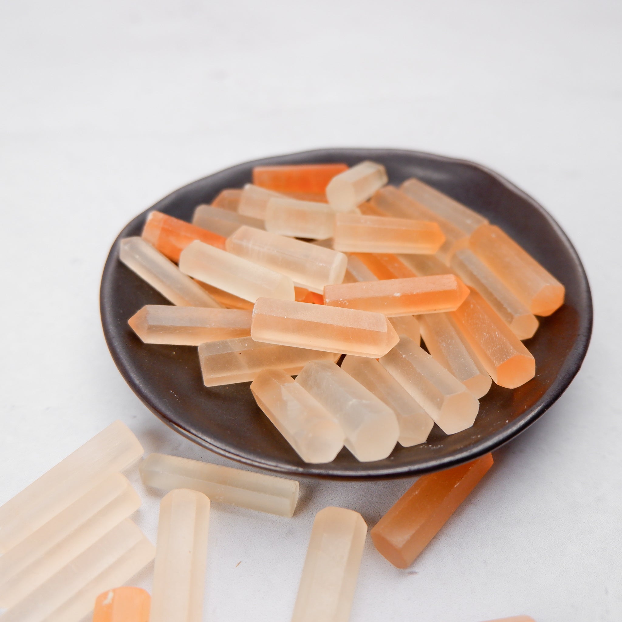 Orange Selenite single gridding point by Noctis Studio, showcasing a smooth, polished crystal with a pointed tip for energy work.