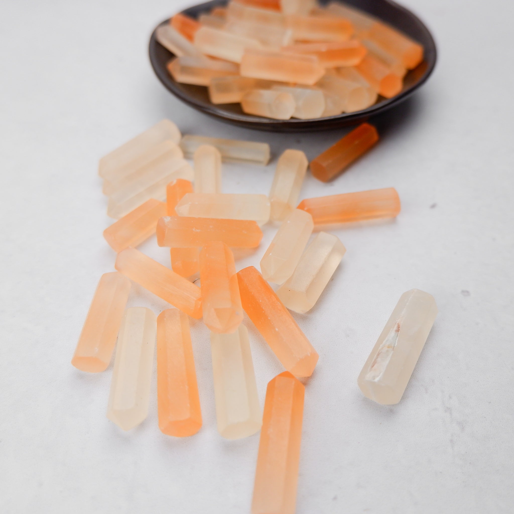 Orange Selenite single gridding point from Noctis Studio with a pointed crystal shape and smooth, polished surface.