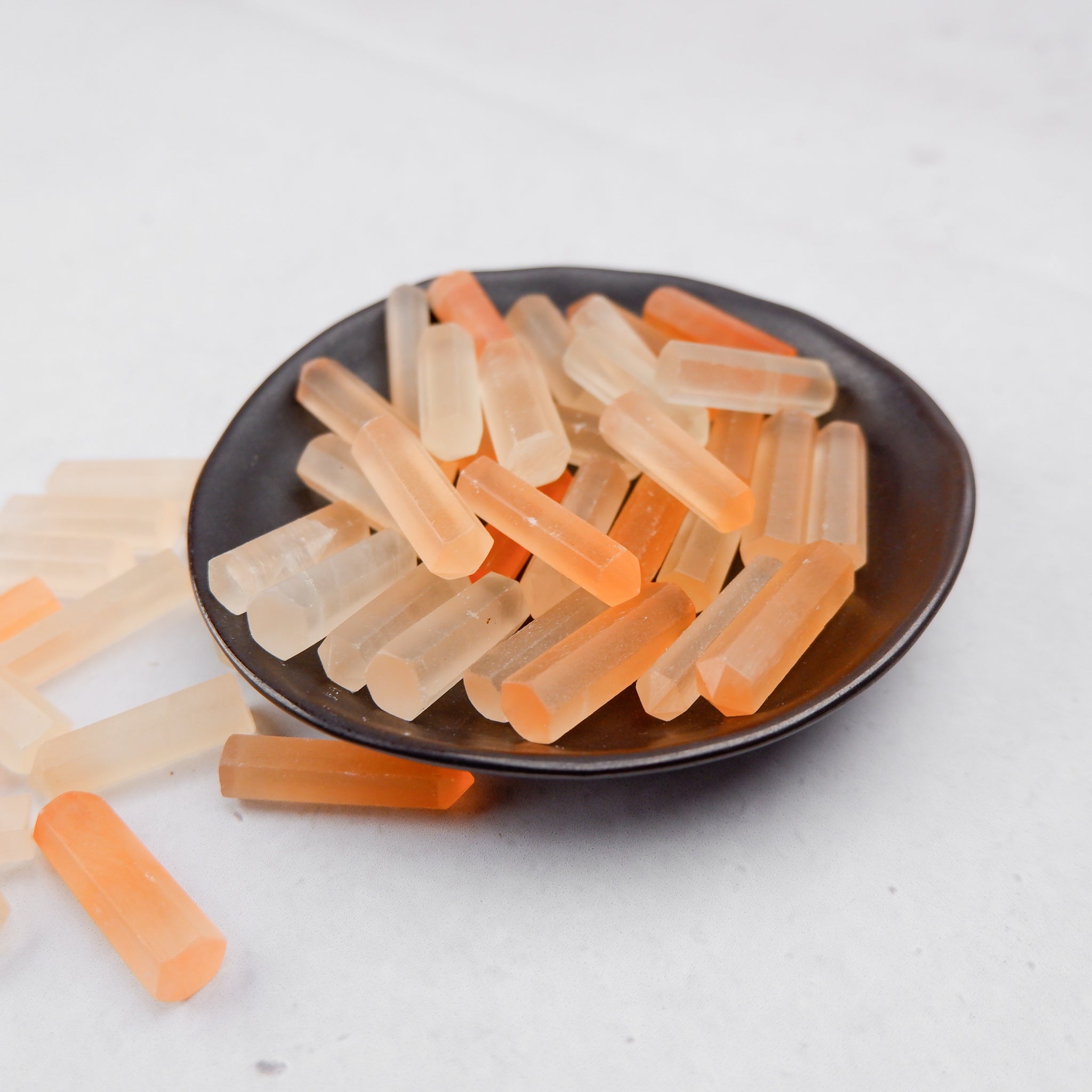Orange Selenite single gridding point from Noctis Studio with smooth, polished surface and pointed tip for crystal healing and energy work.