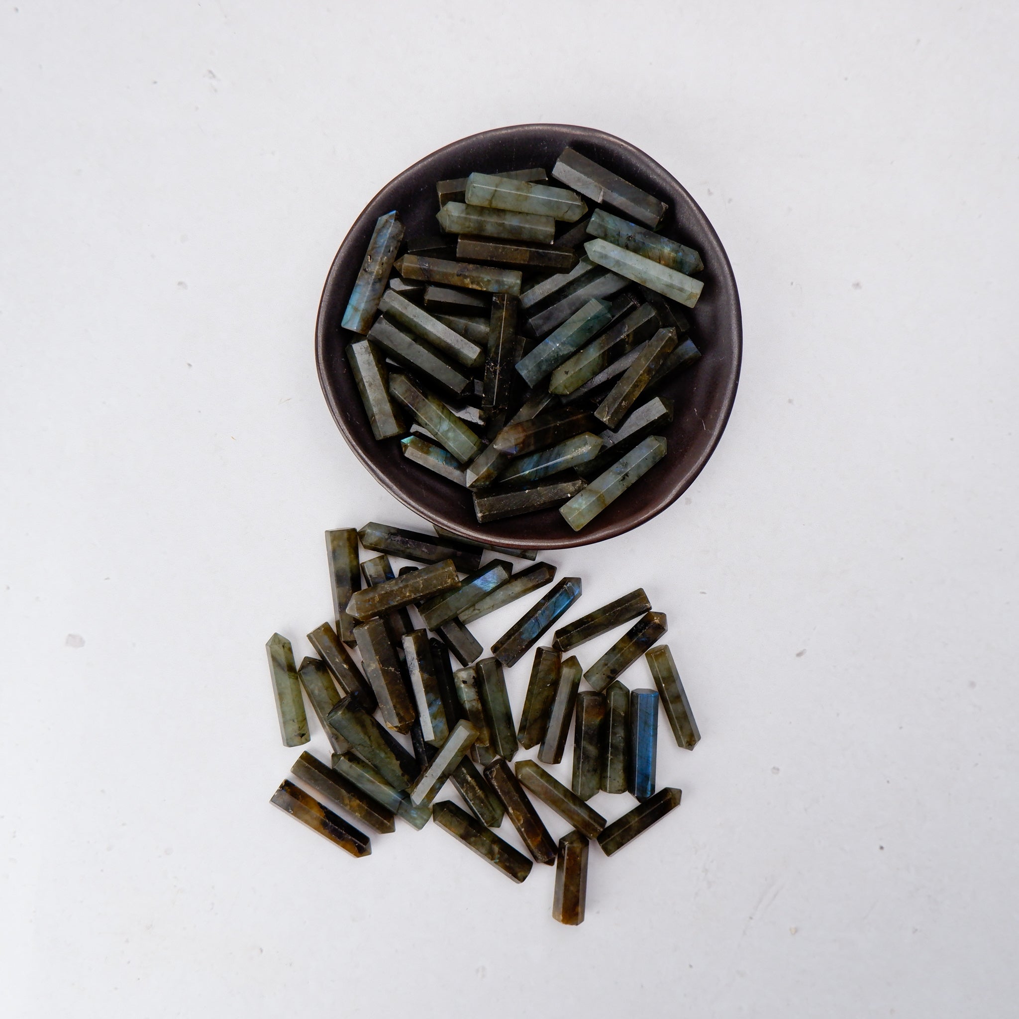 Labradorite single gridding point from Noctis Studio showcasing iridescent stone with pointed tip and natural crystal features.