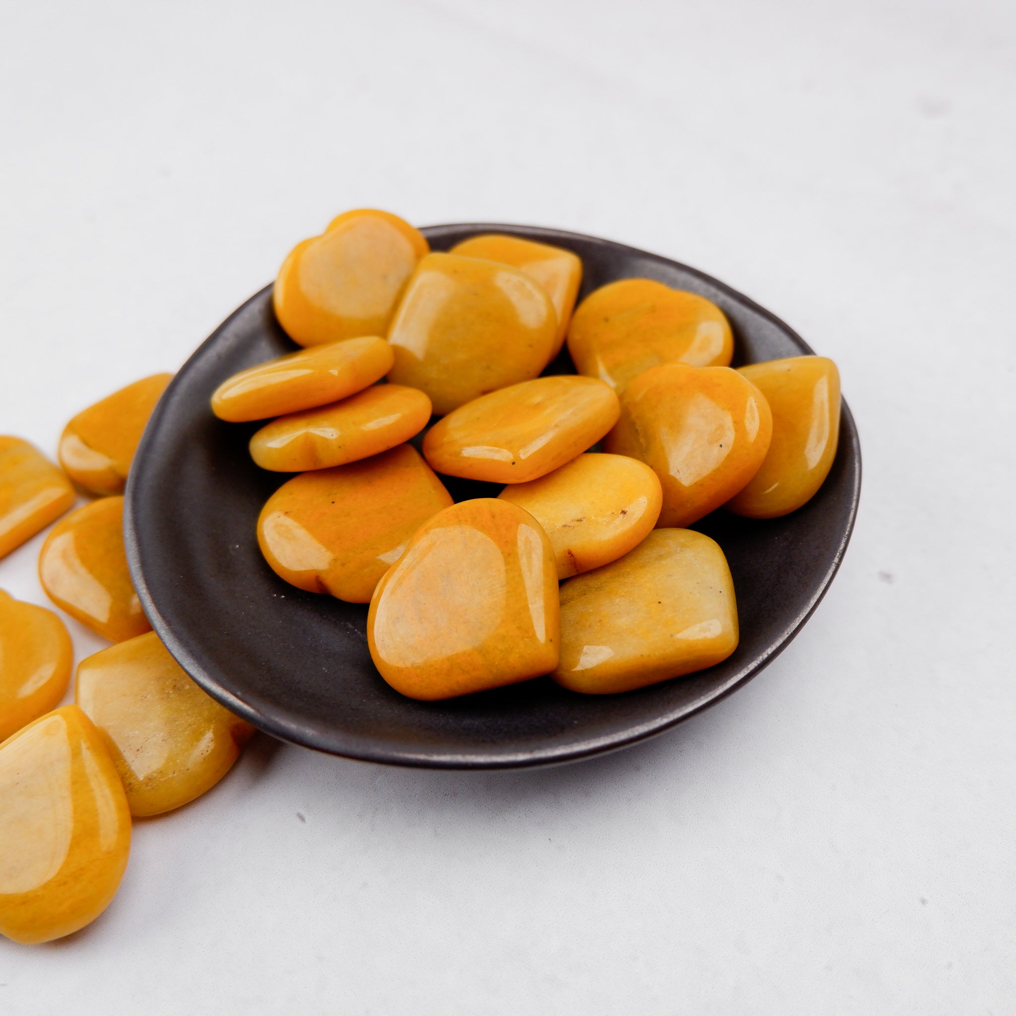Yellow aventurine heart gemstone from Noctis Studio, smooth polished stone with vibrant yellow color and rounded heart shape.
