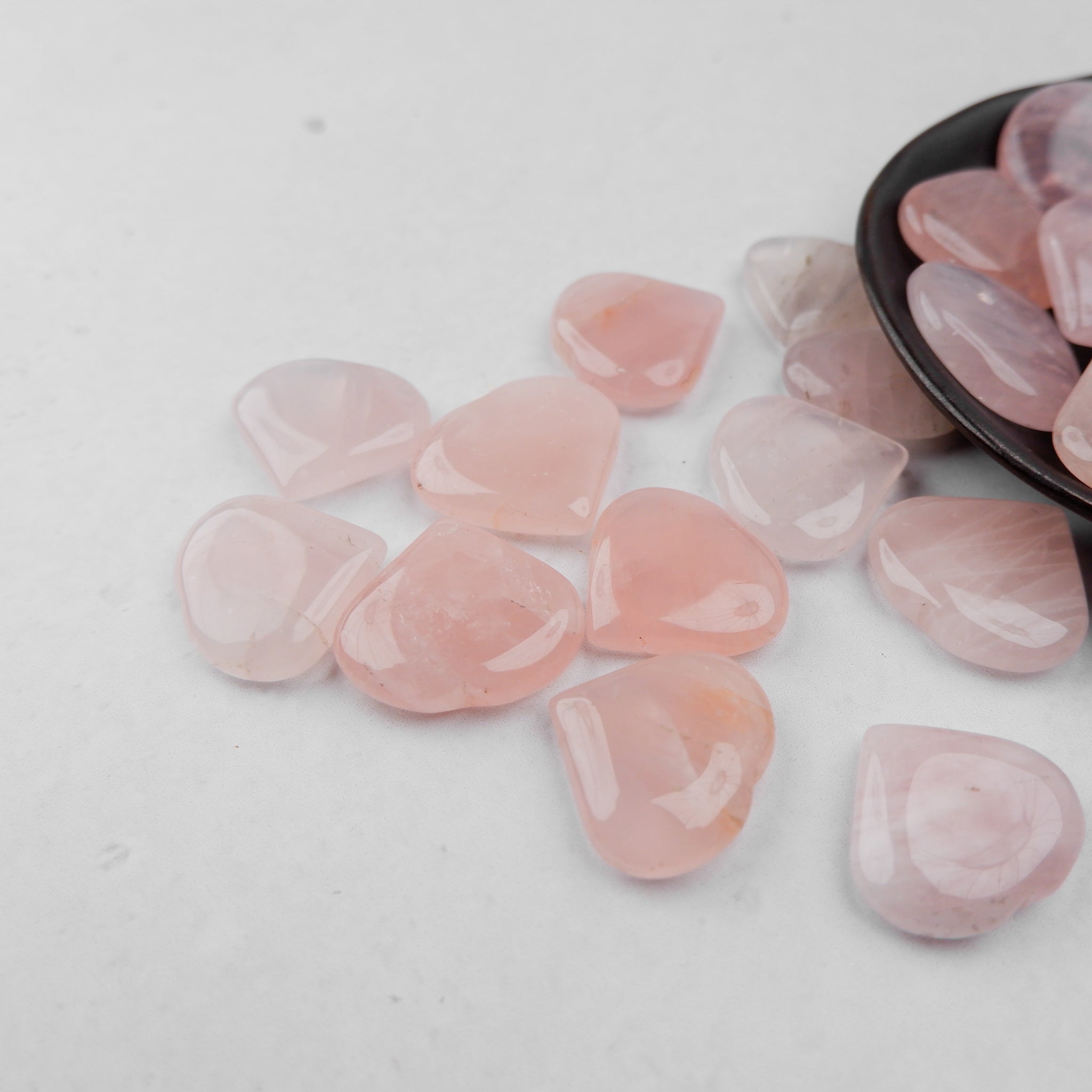 Pink rose quartz heart sculpture by Noctis Studio, smooth polished gemstone with natural color variations and a rounded heart shape.