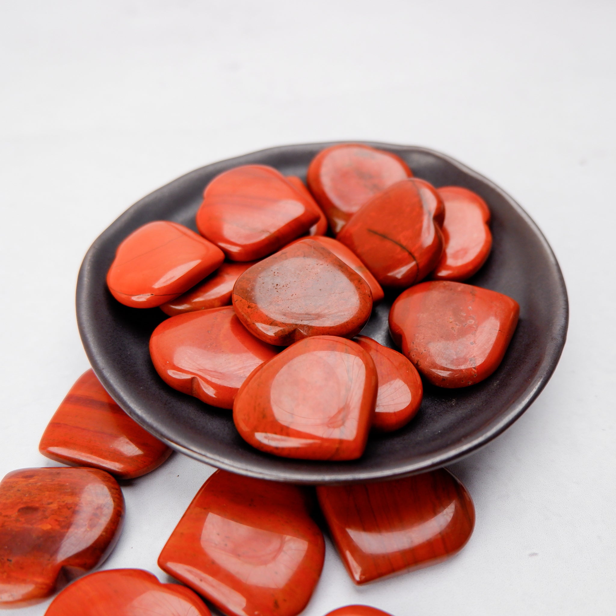 Red Jasper heart sculpture by Noctis Studio, polished stone with natural red and brown hues, smooth and heart-shaped.