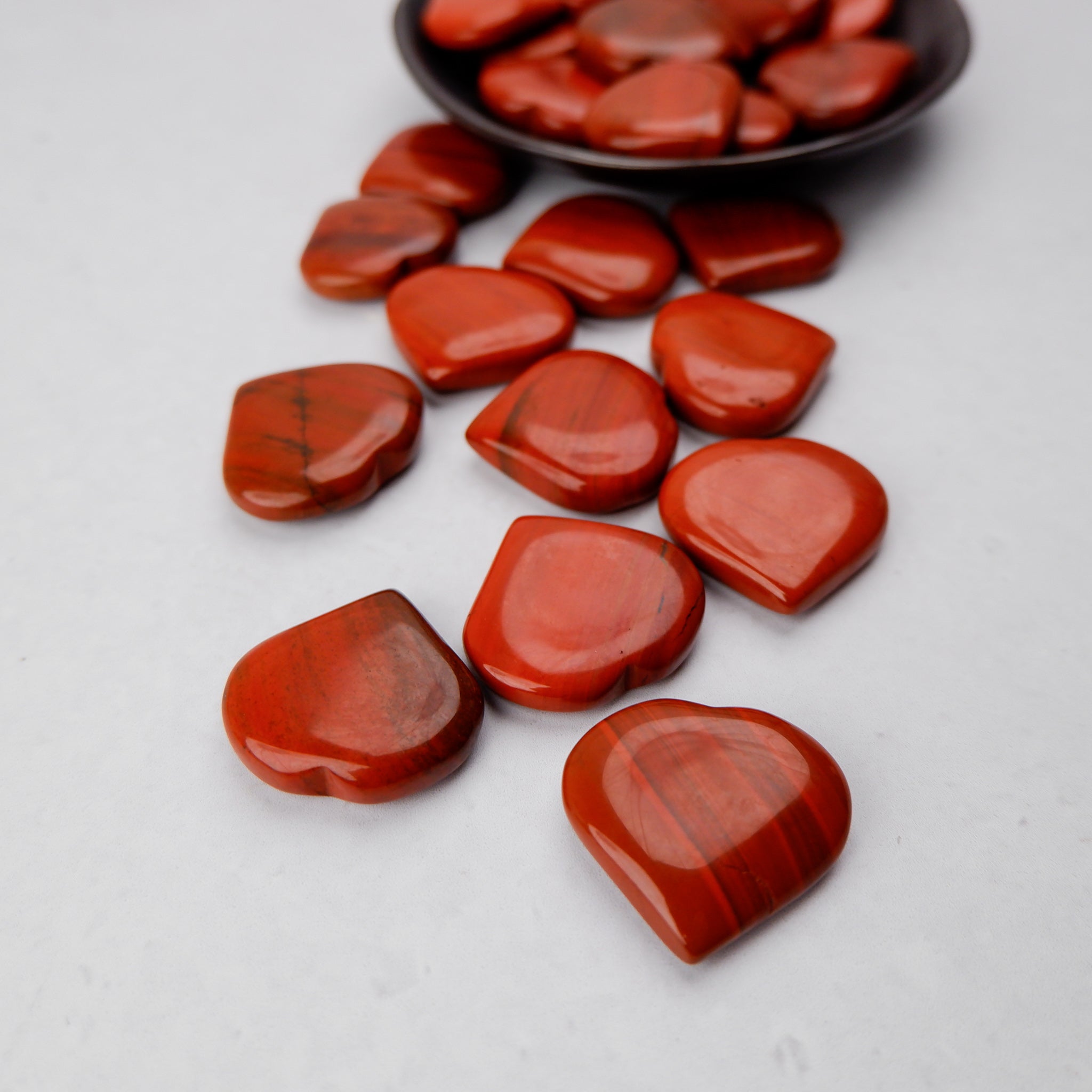 Red Jasper heart sculpture by Noctis Studio, smooth polished stone with natural red and earthy tones, heart-shaped decorative piece.