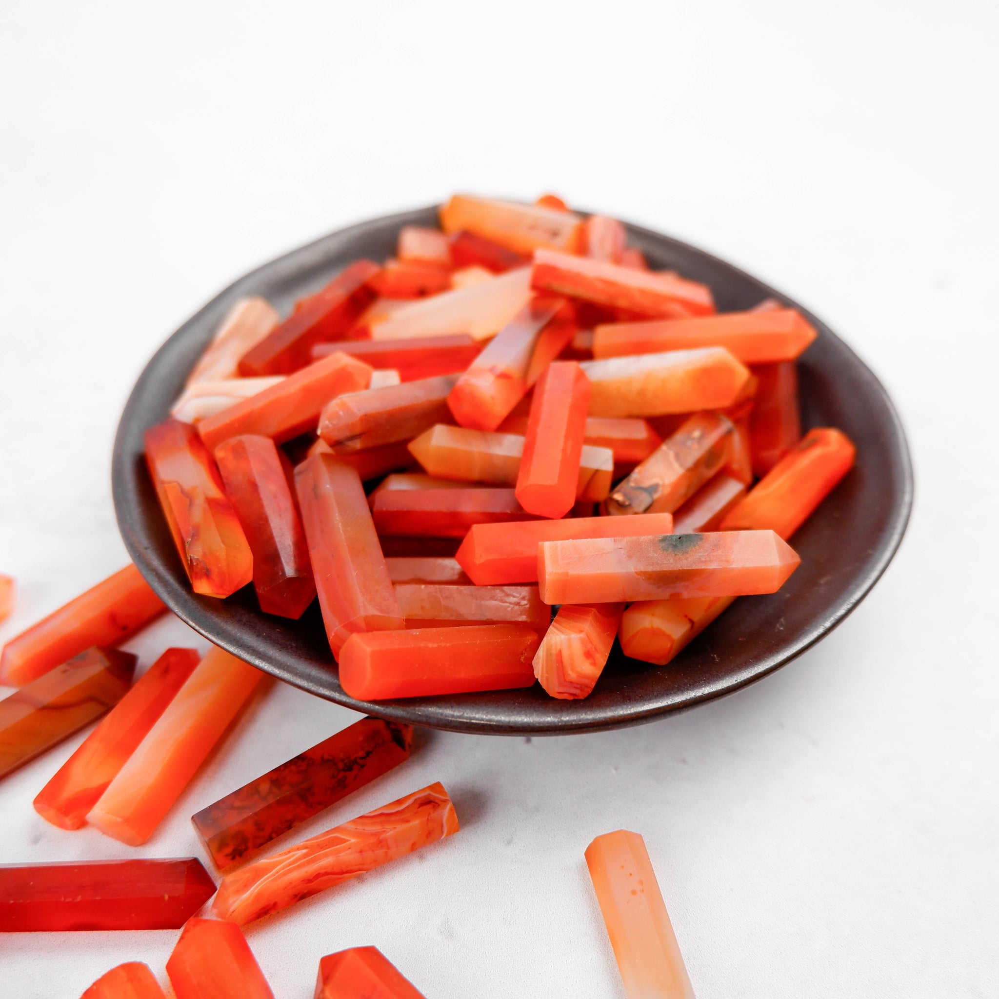 Noctis Studio Carnelian Single Gridding Point showing a polished, reddish-orange gemstone tool for jewelry making.