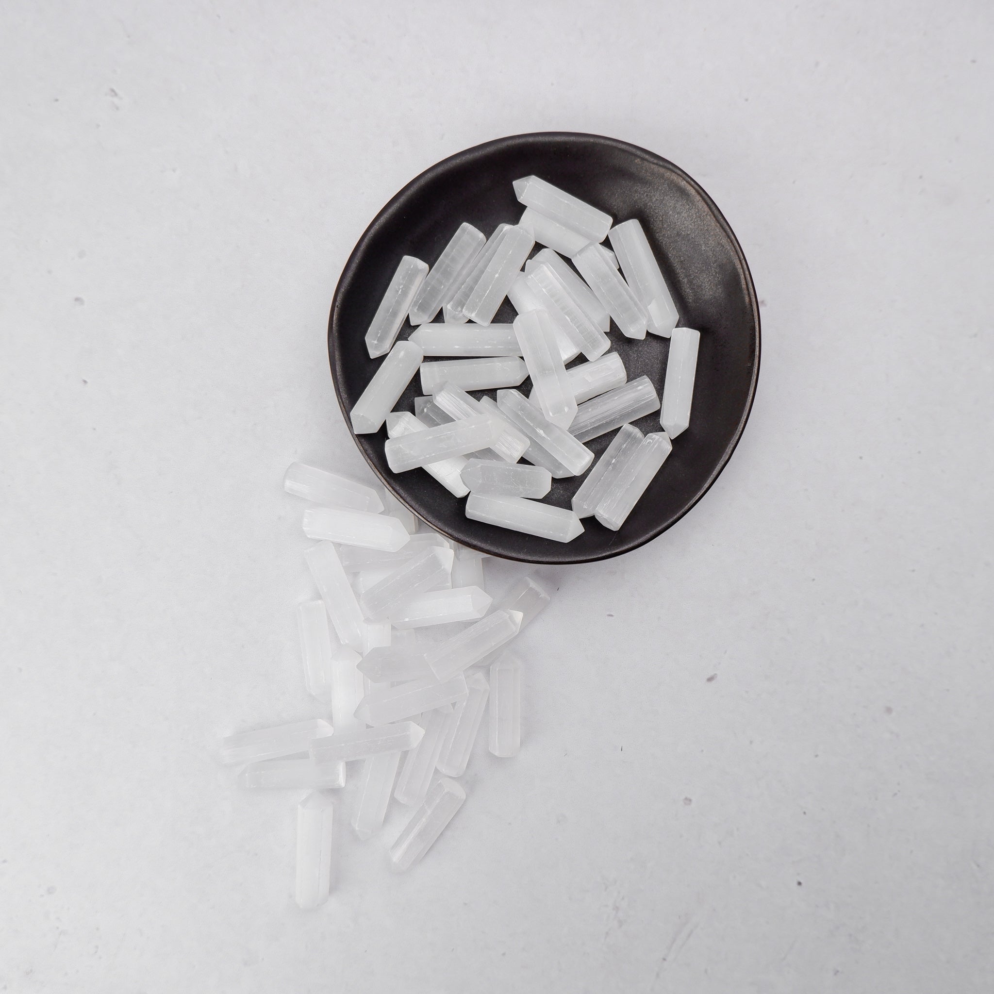Selenite single gridding point from Noctis Studio, clear crystal with pointed tip, used for energy work and crystal grids.