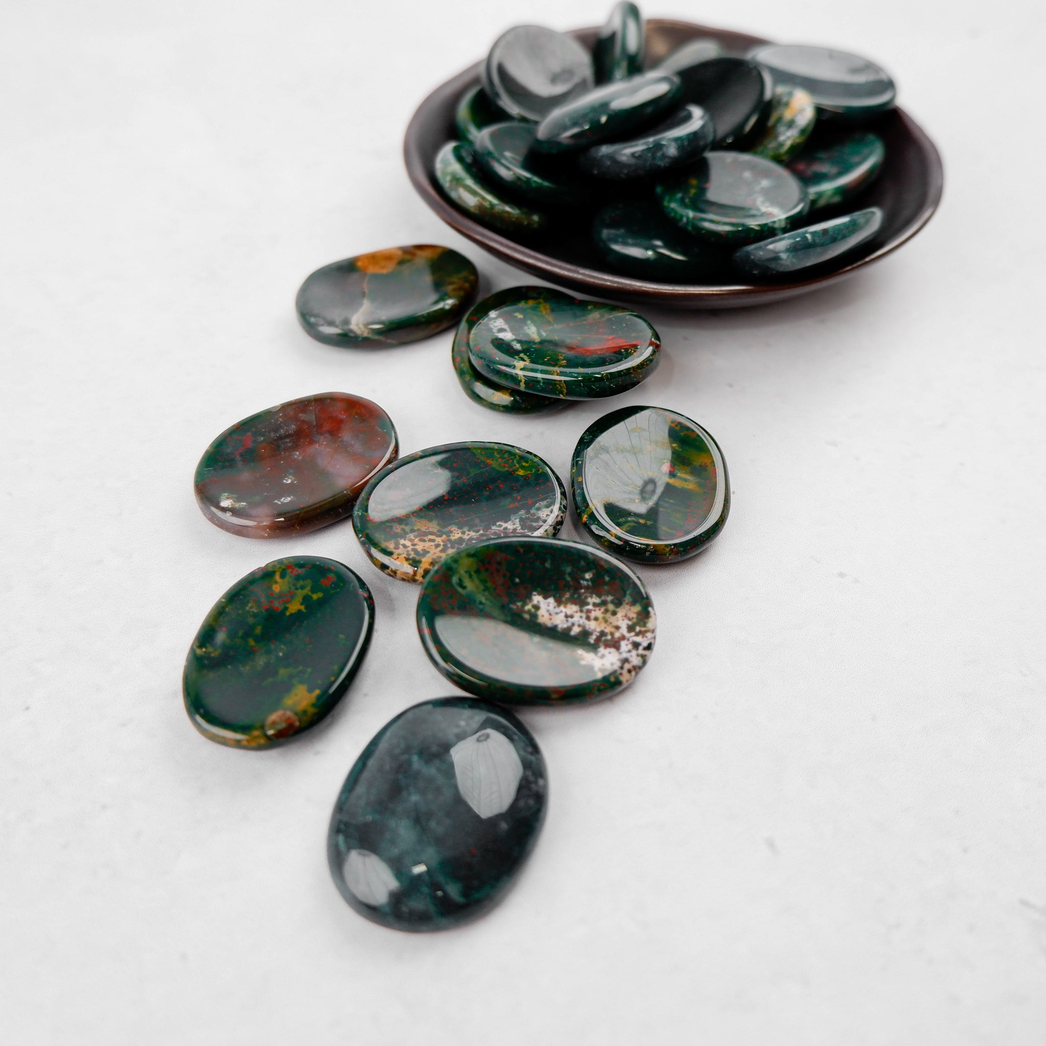 Bloodstone worry stone from Noctis Studio, smooth polished gemstone for stress relief and meditation.