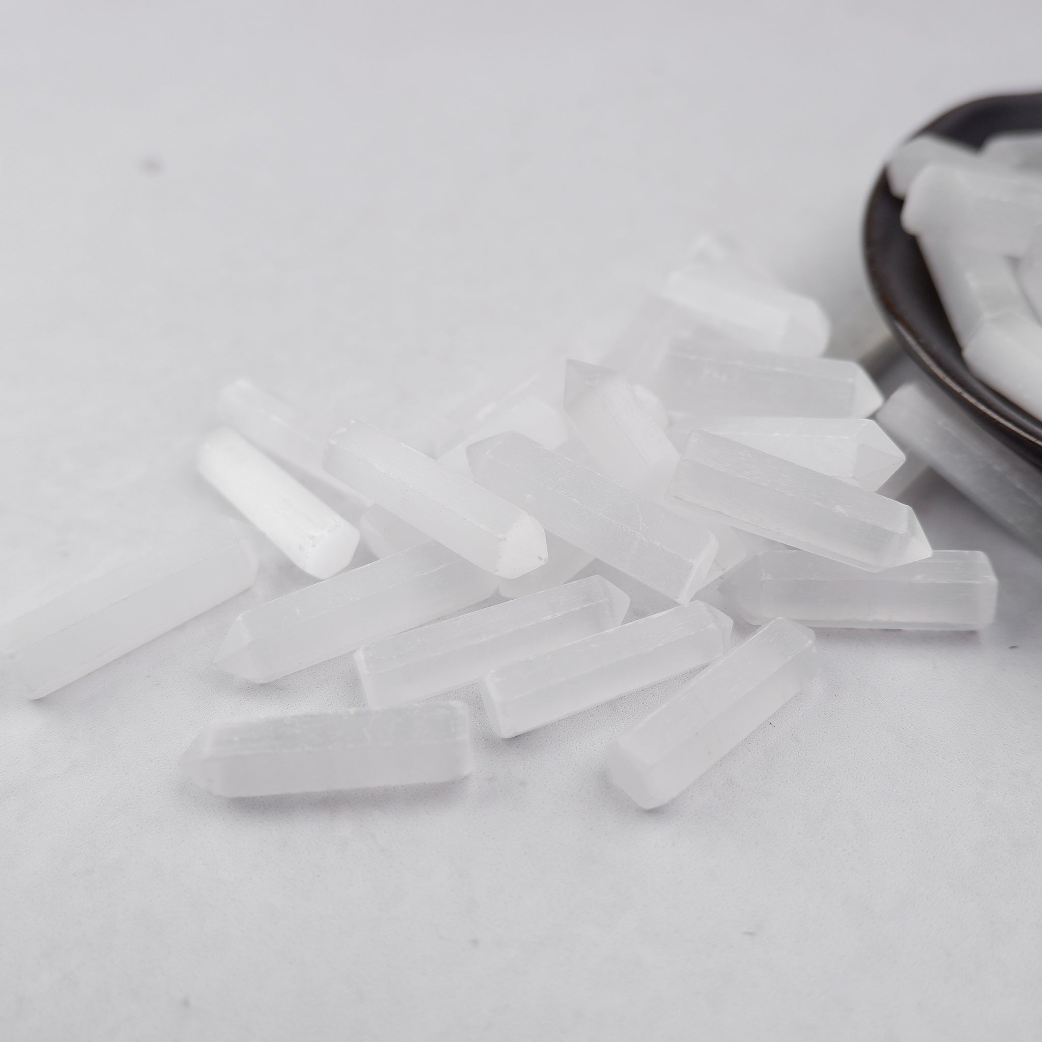 Selenite single gridding point by Noctis Studio showing a smooth, translucent white crystal point for energy healing and spiritual work.
